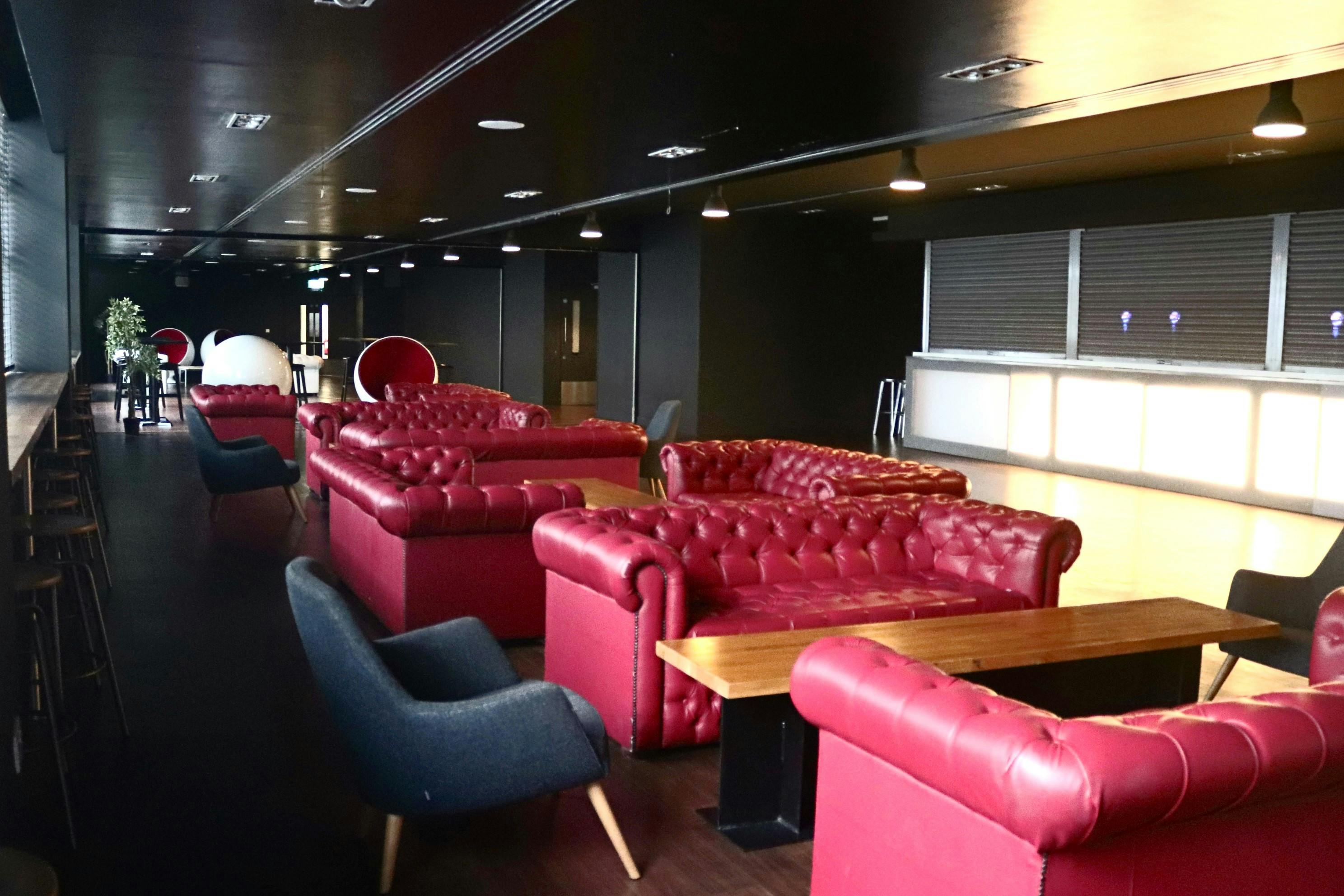 Hello Wembley Lounge at OVO Arena, featuring plush red leather sofas for networking events.