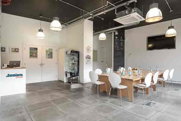 Modern meeting room with wooden table, ideal for workshops and presentations.