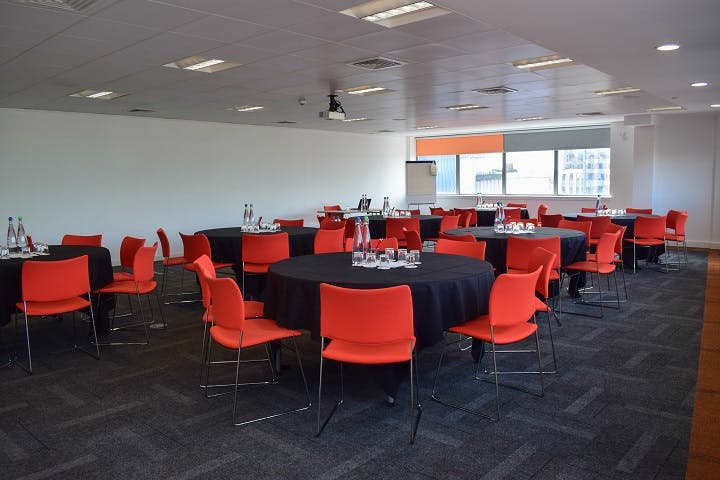 Modern event space in Glasgow with round tables, ideal for workshops and networking.