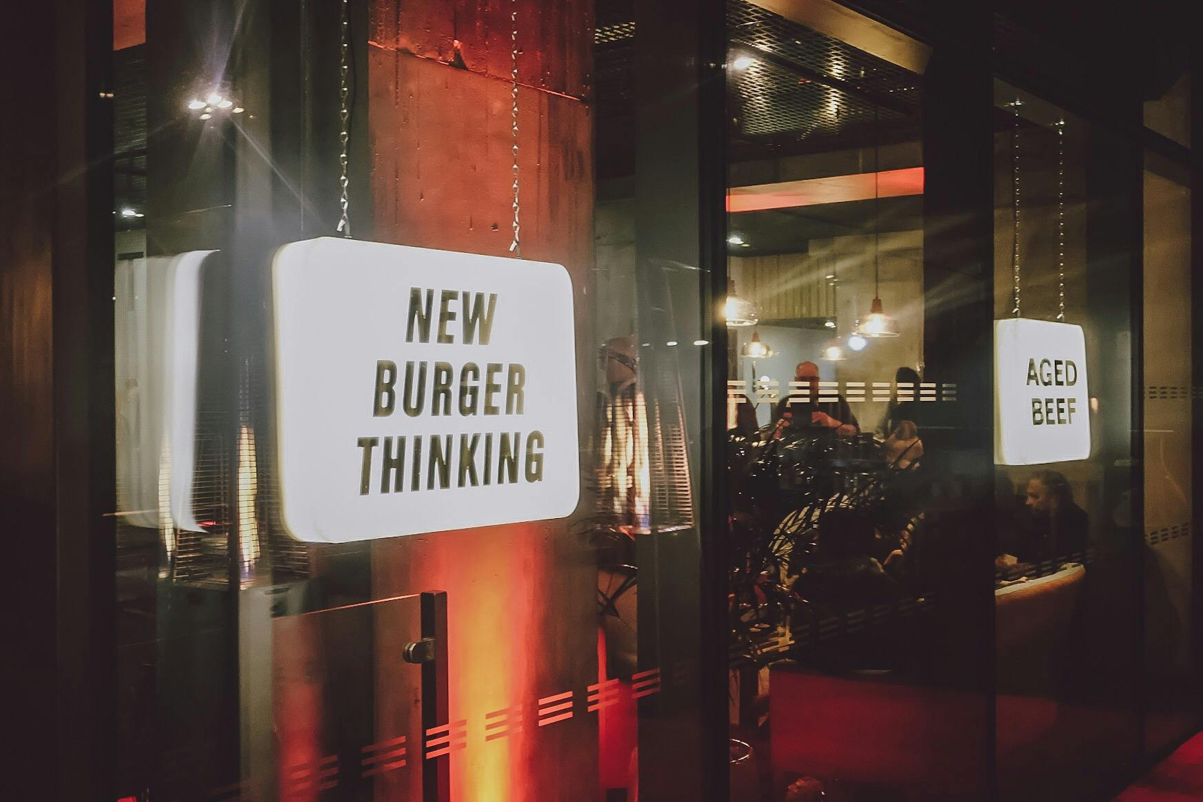 Vibrant Cut and Grind venue with "New Burger Thinking" signage for events and networking.