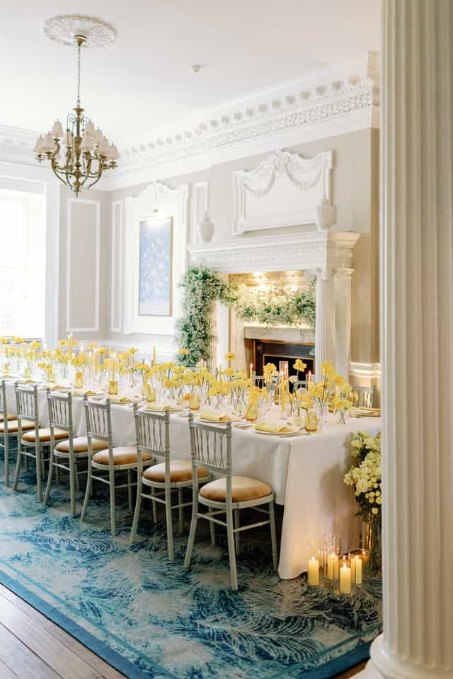 Elegant wedding banquet table with yellow flowers and candles at Six Park Place.