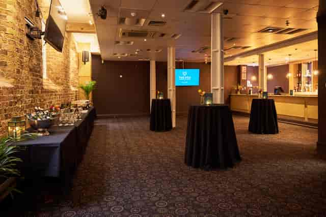 Industrial-chic private bar at Fox Excel set for networking mixer and corporate event space.