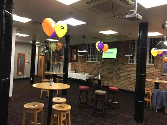 Industrial private bar venue with high-top tables for corporate networking events.