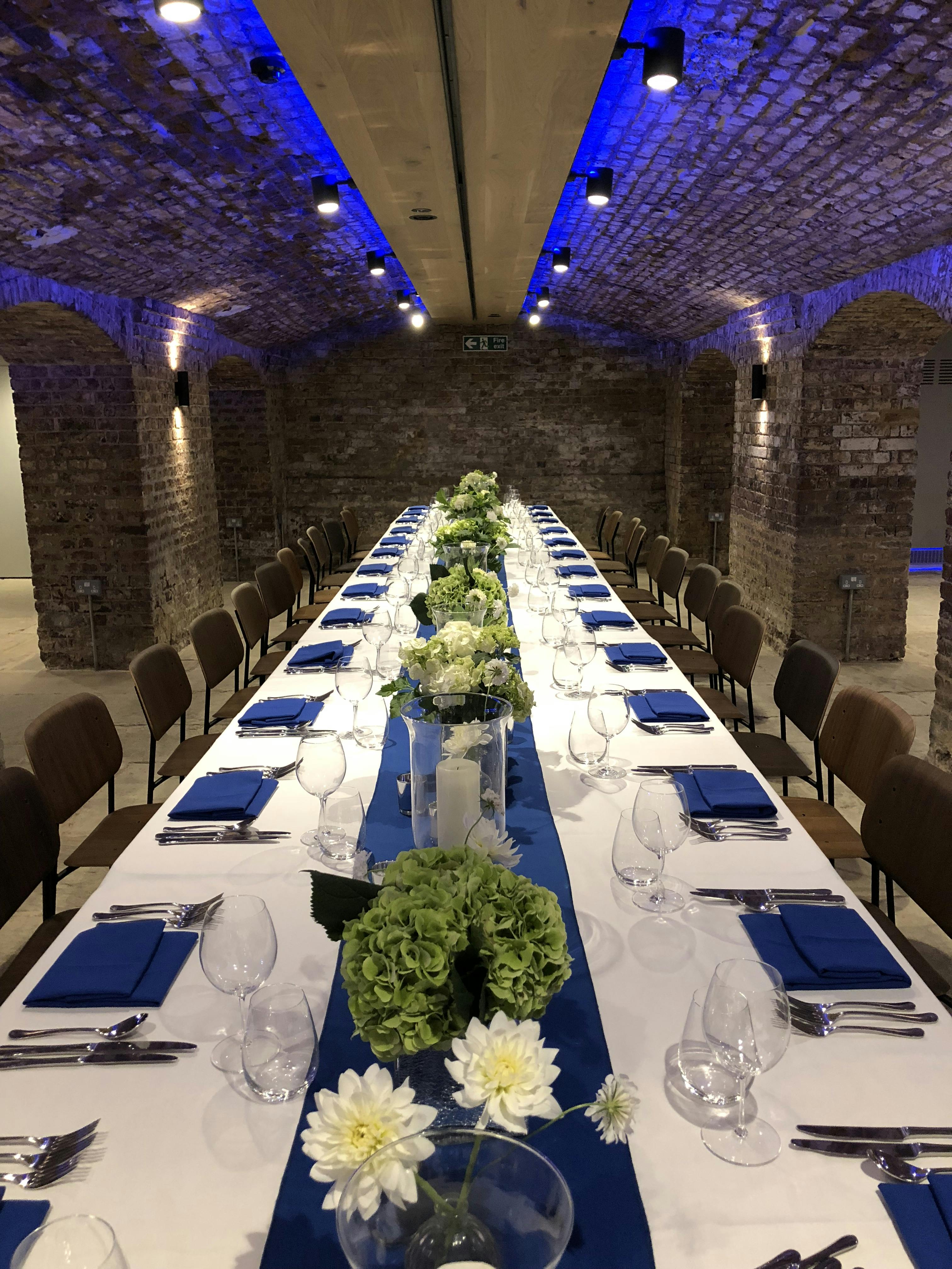 Elegant banquet table with white flowers at London Bridge Arches for corporate events.
