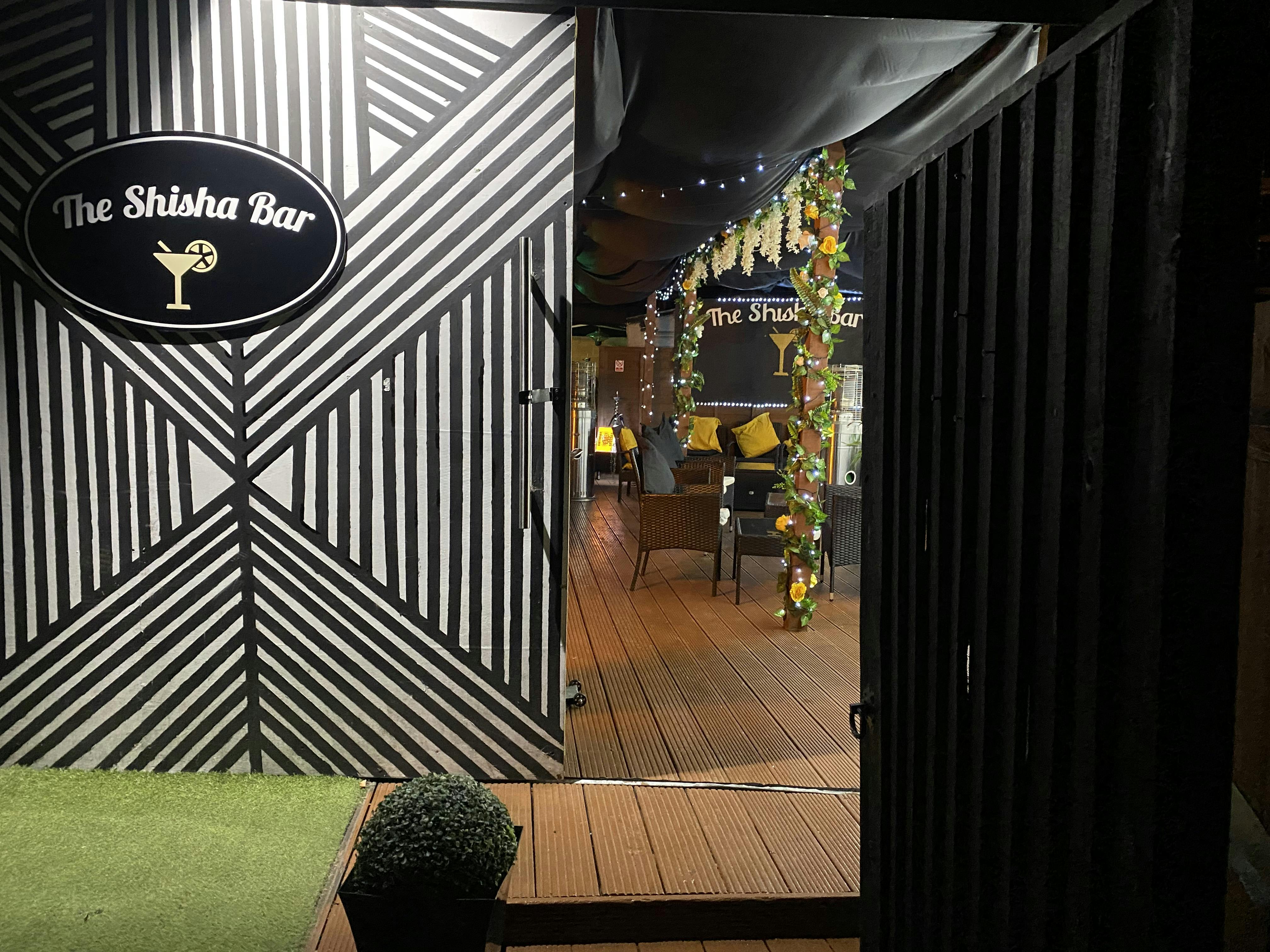 Stylish entrance of The Shisha Bar with vibrant decor for social gatherings and events.