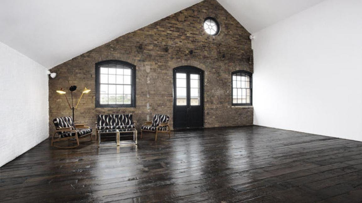 Versatile event space with exposed brick and natural light at Spring Studios.