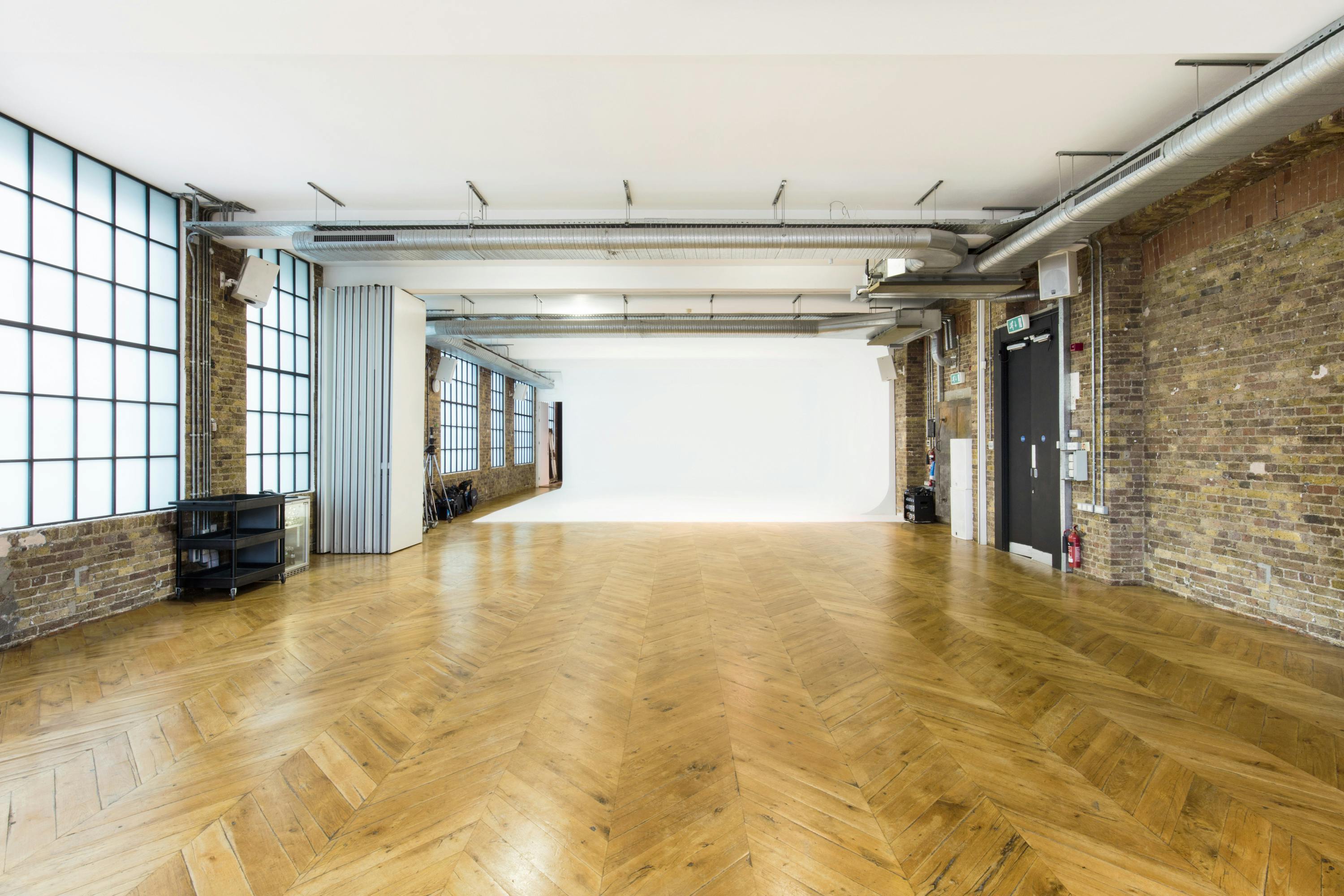 Versatile event space with natural light, polished wood floor for workshops and presentations.