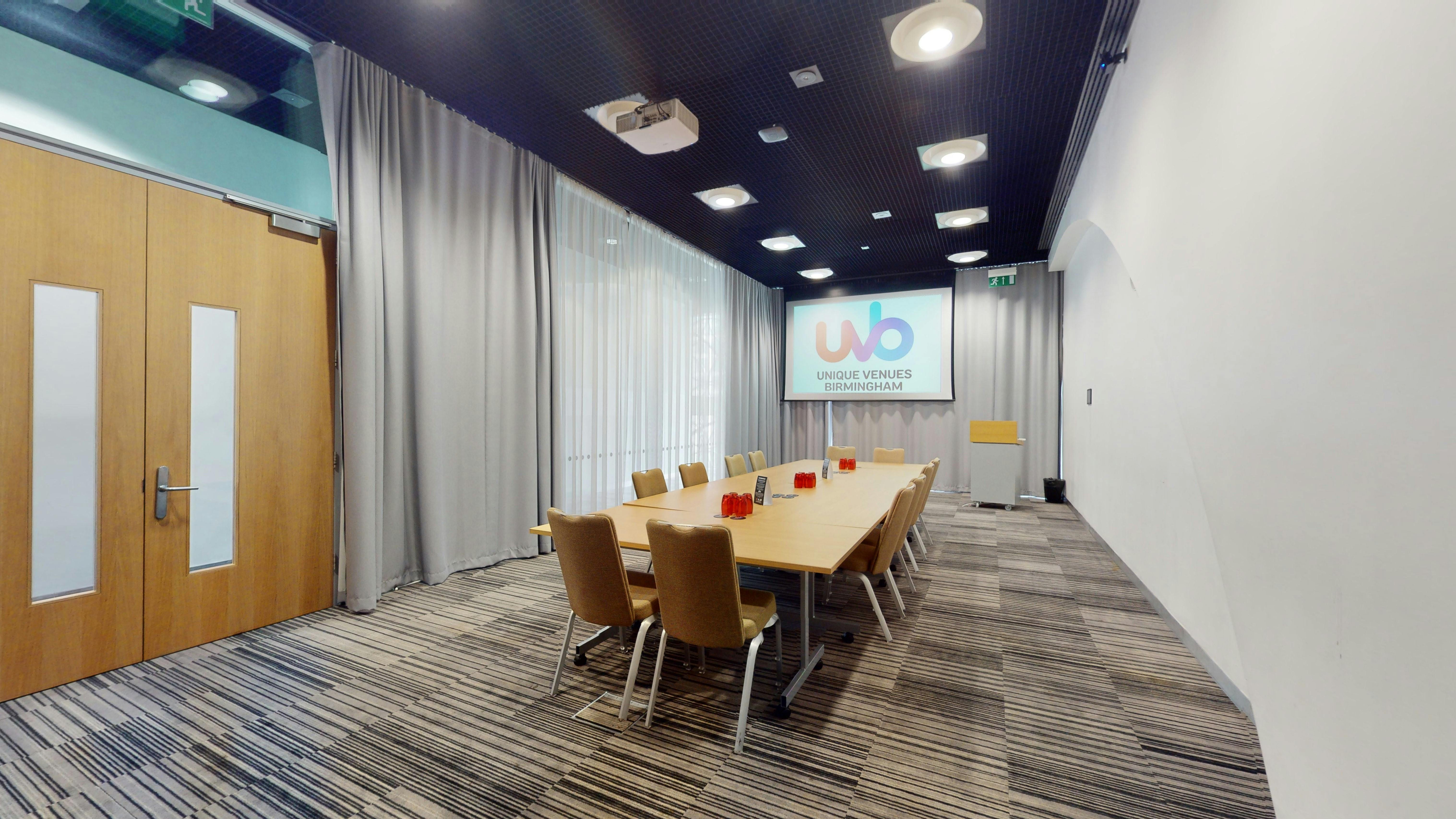 Modern meeting room LOB 102 with large table, ideal for workshops and strategic meetings.