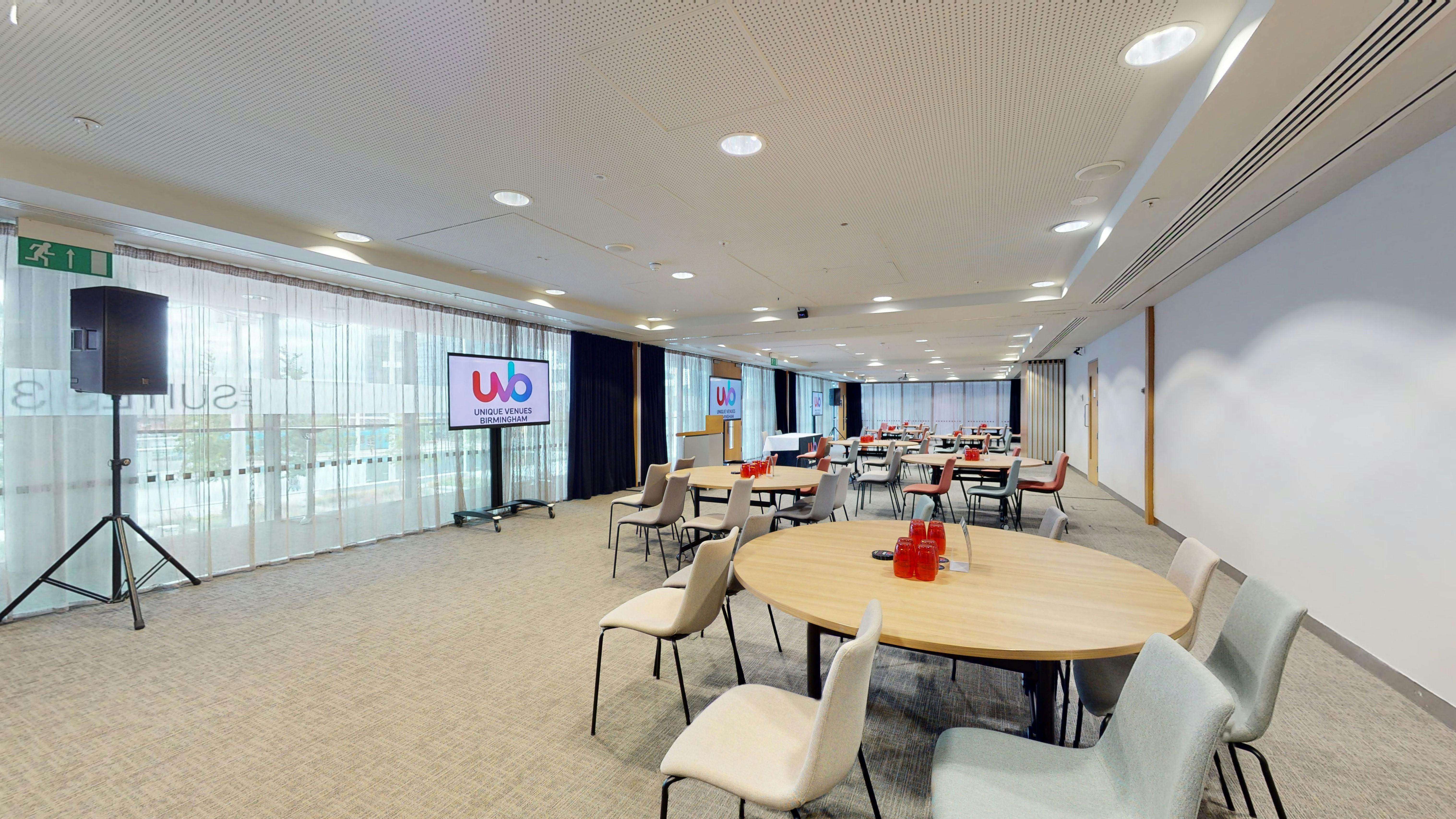 Versatile meeting space with round tables and AV setup at Unique Venues Birmingham.