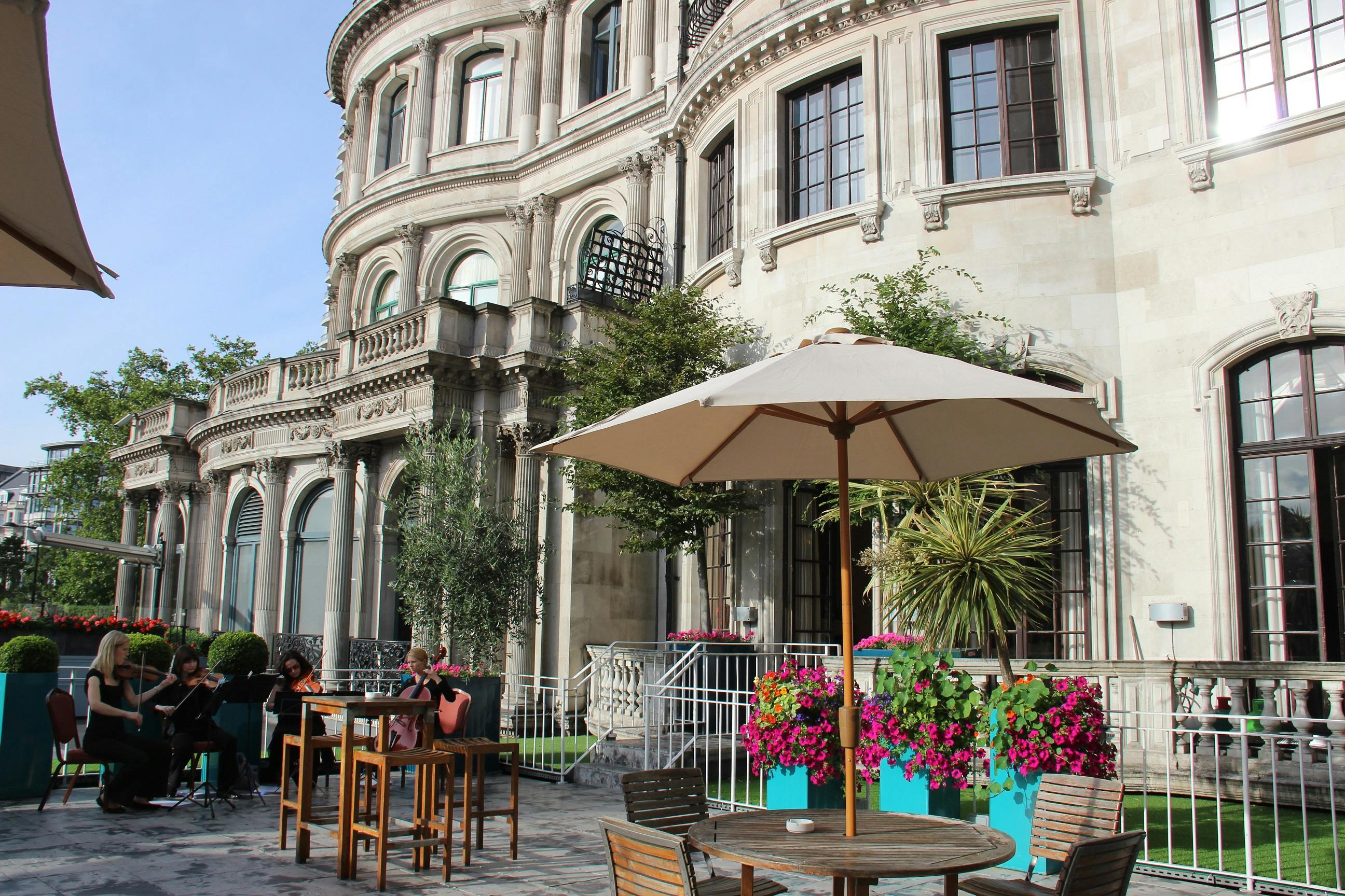 Elegant outdoor summer party at No. 4 Hamilton Place with vibrant flowers and musicians.