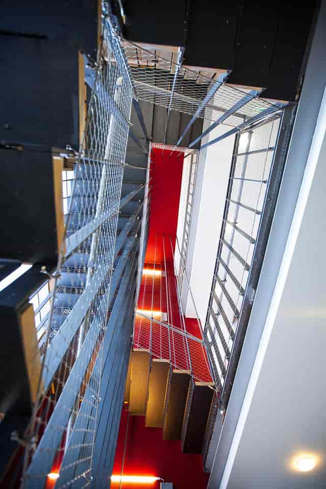Modern industrial staircase with red accent wall at Siobhan Davies Studios for events.