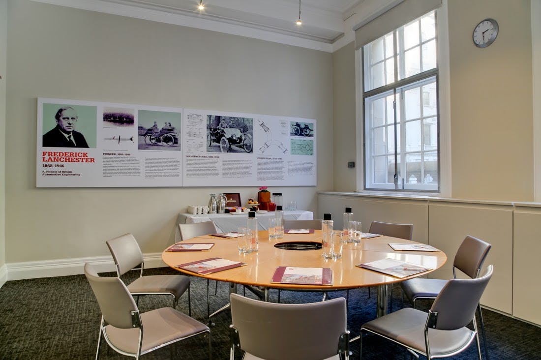 Frederick Lanchester in a bright meeting room with a round table for collaborative events.