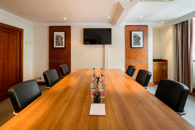 Meeting room at Thistle Marble Arch, featuring a spacious wooden table and modern decor.