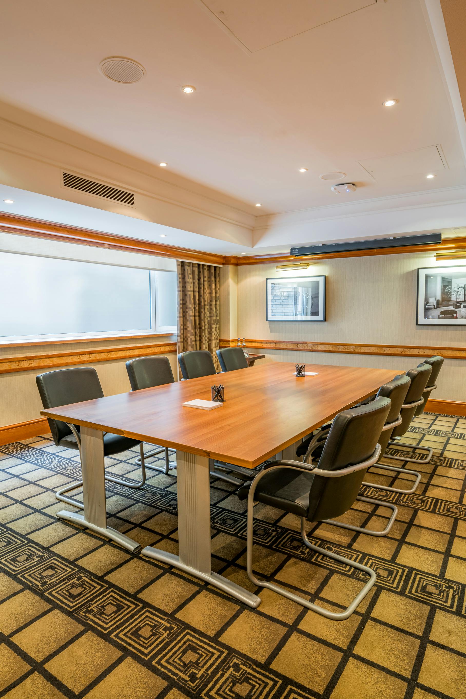 Downing Street meeting room with wooden table, ideal for professional gatherings and brainstorming.