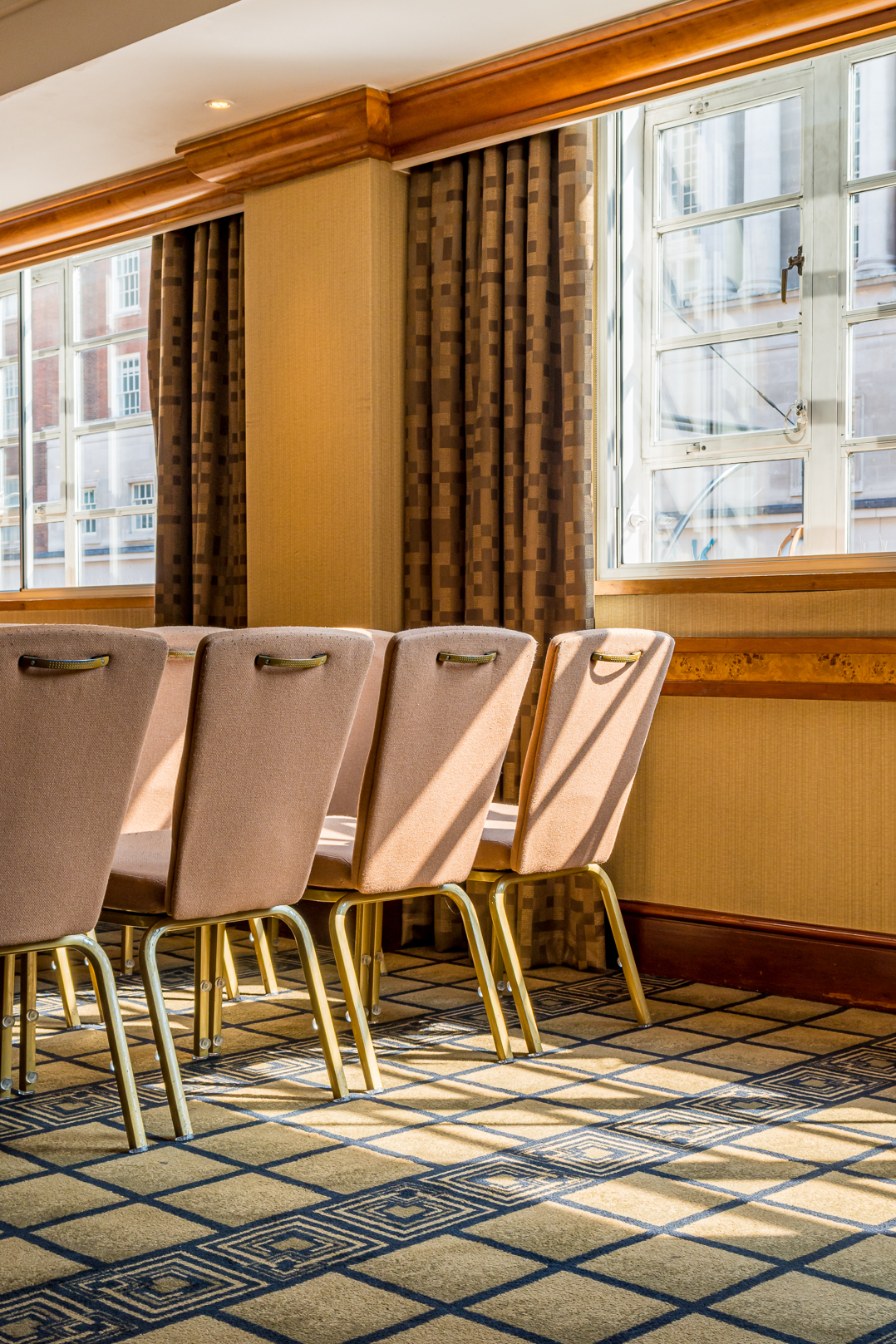 Elegant meeting room with upholstered chairs, ideal for networking and workshops. - Banner