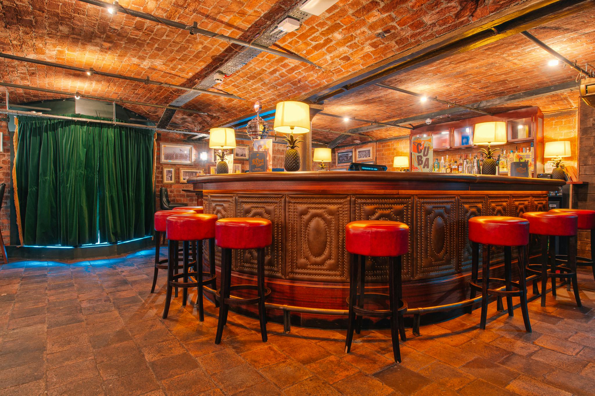 Havana Bar Liverpool: rustic wooden bar with red stools, perfect for networking events.