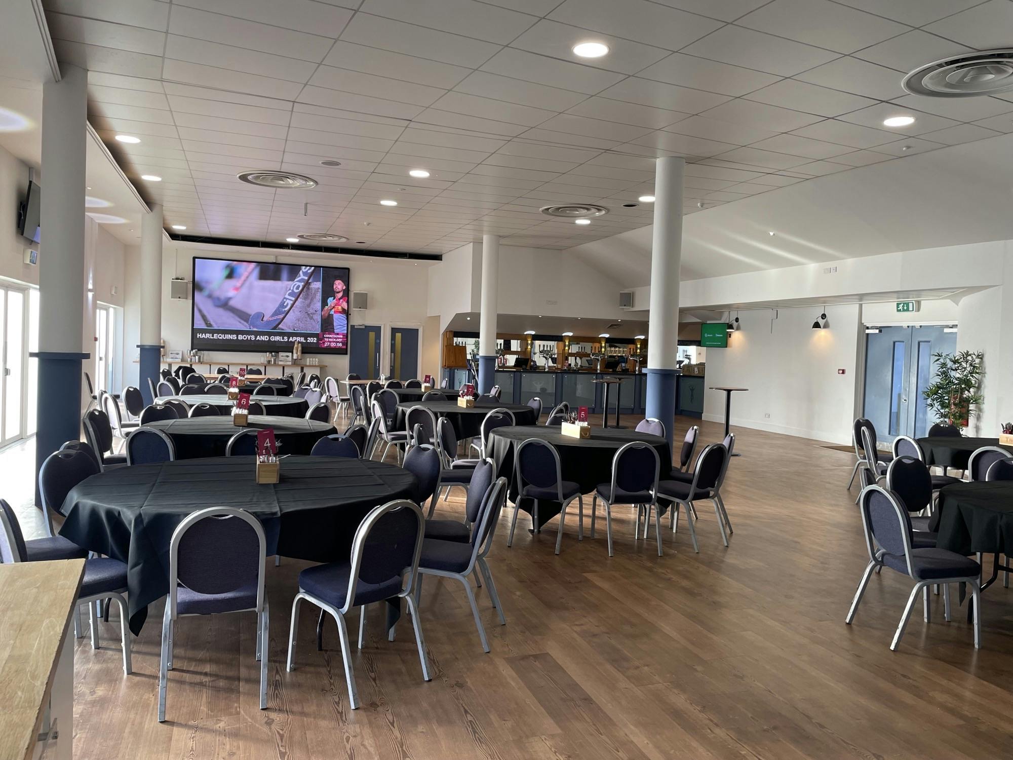 Debentures event setup with round tables in Twickenham Stoop Stadium for networking.