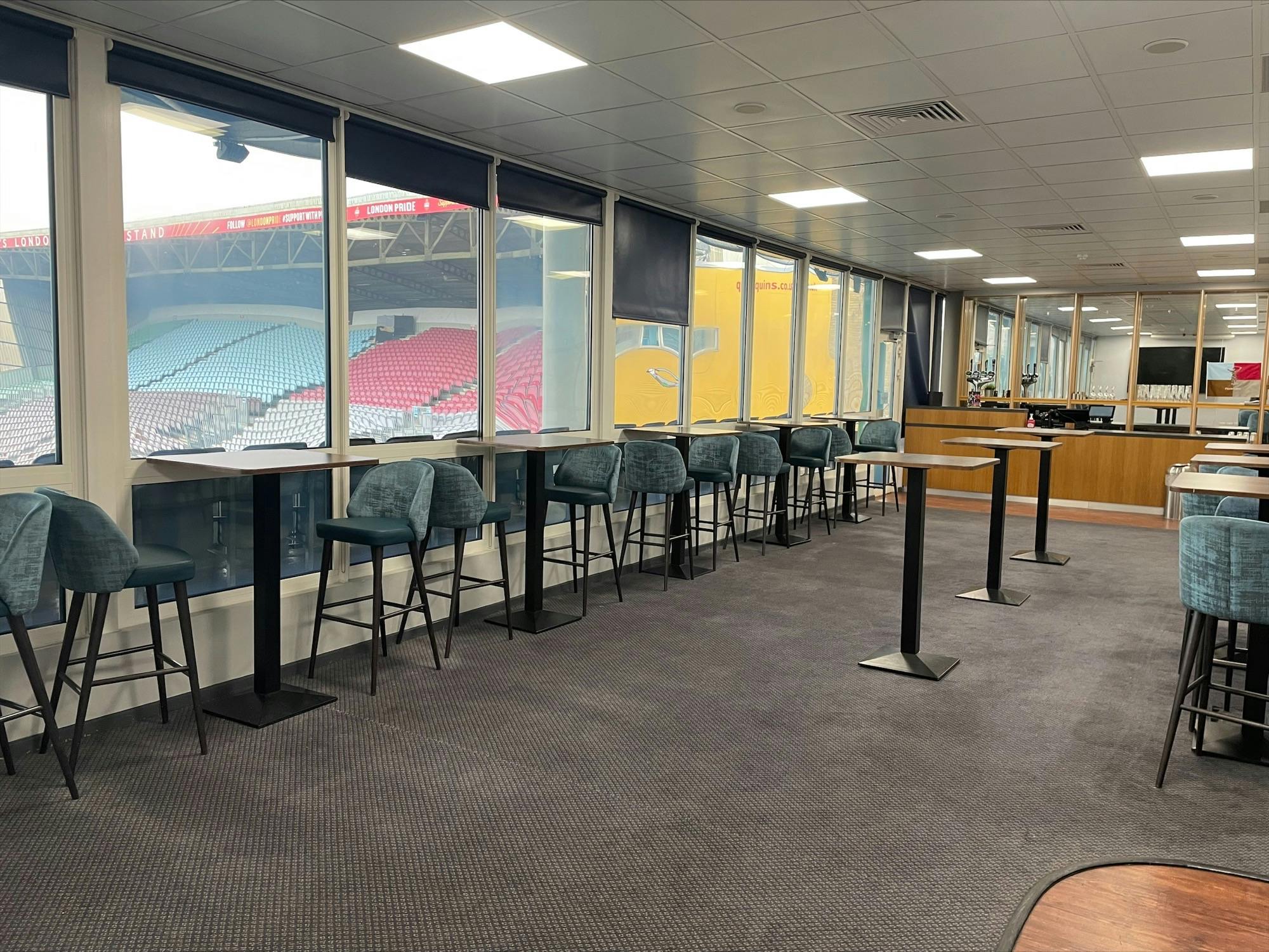 Modern event space at Twickenham Stoop Stadium with high-top tables for corporate gatherings.