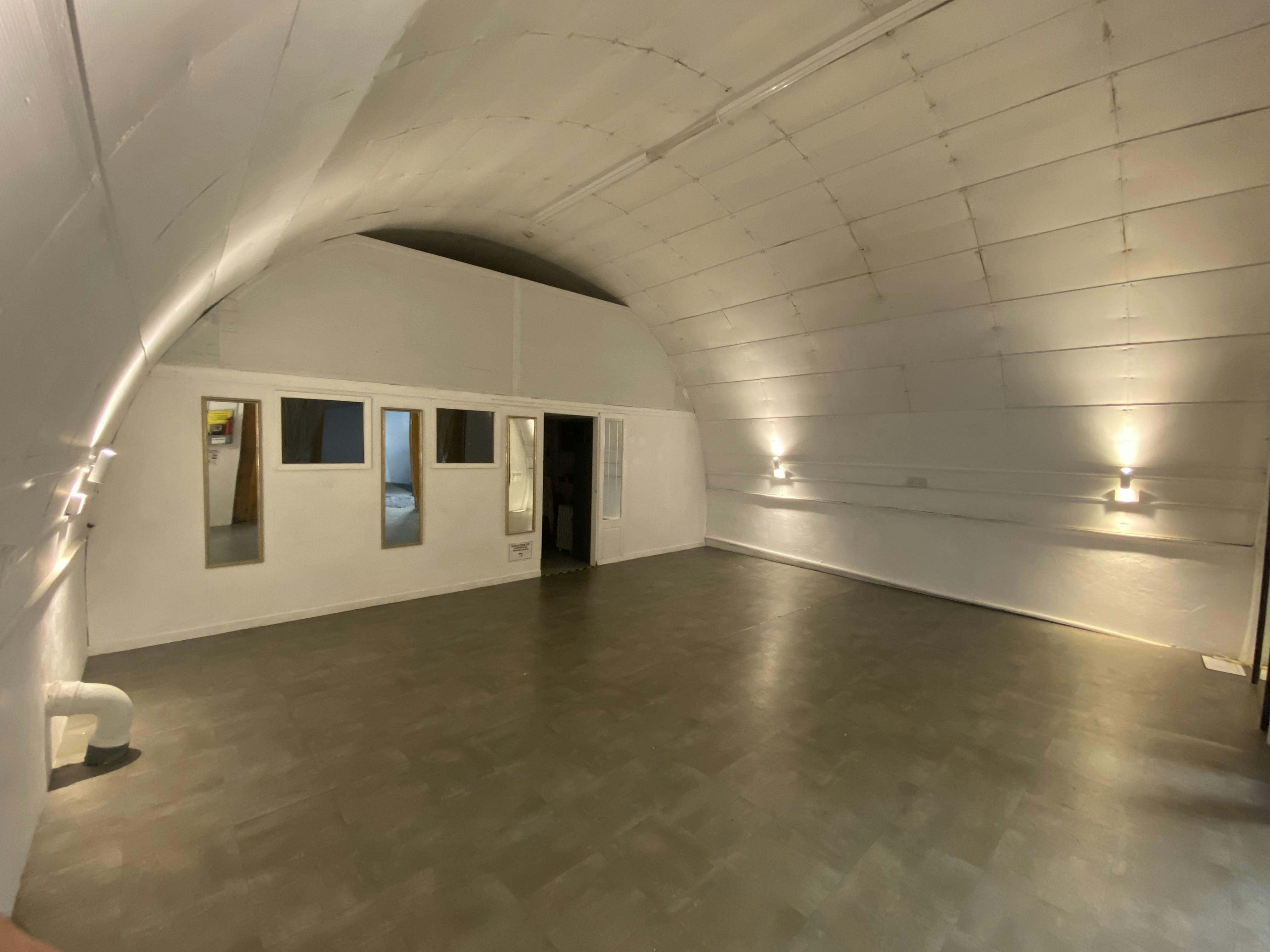 Versatile event space with arched ceiling, ideal for workshops and gatherings.