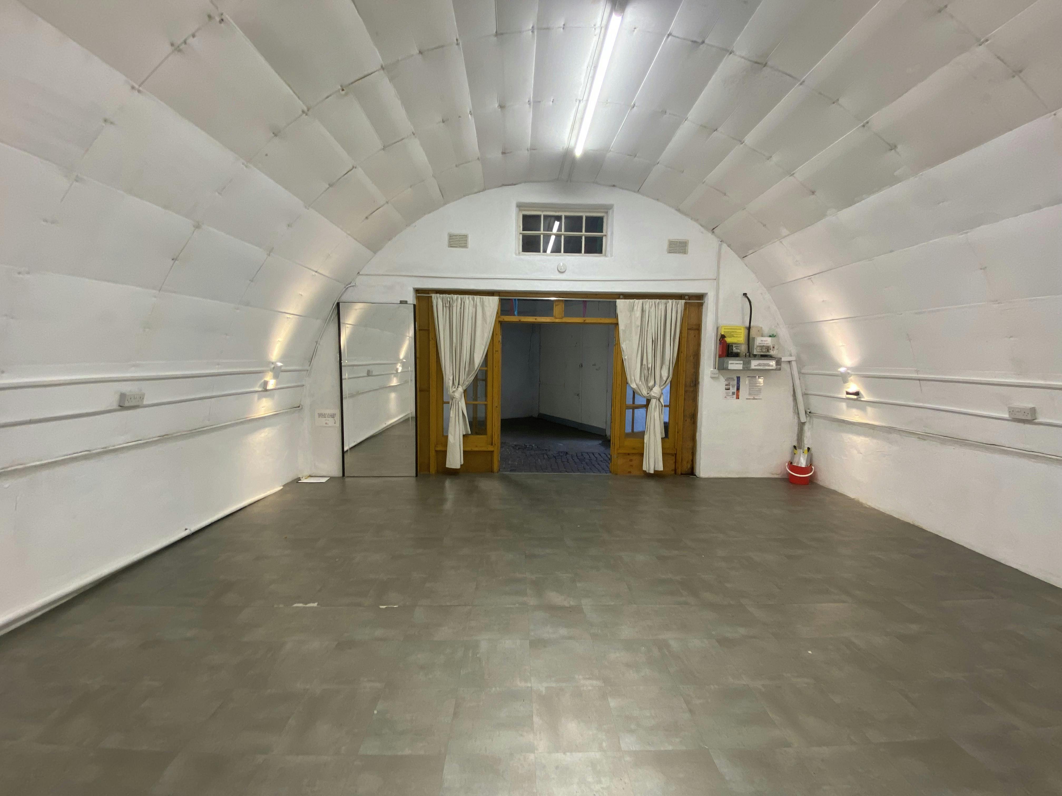 Versatile event space with arched ceiling for workshops and seminars at Sunshine International Arts.