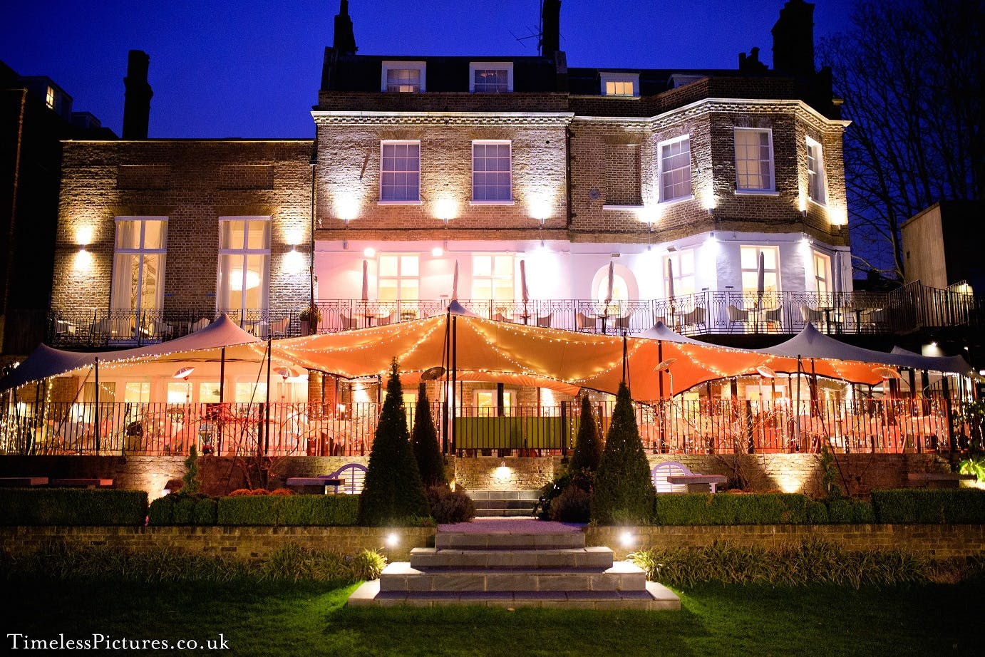 Elegant garden venue with warm lighting, perfect for weddings and upscale events.