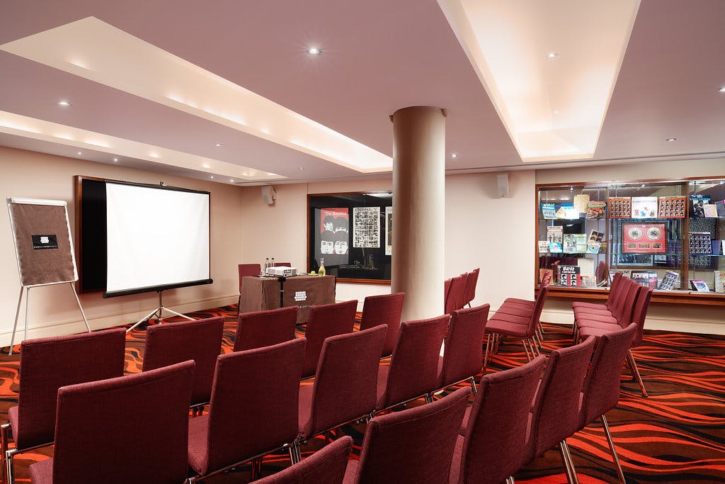 Hard Days Night Suite meeting space with projector, ideal for workshops and conferences.