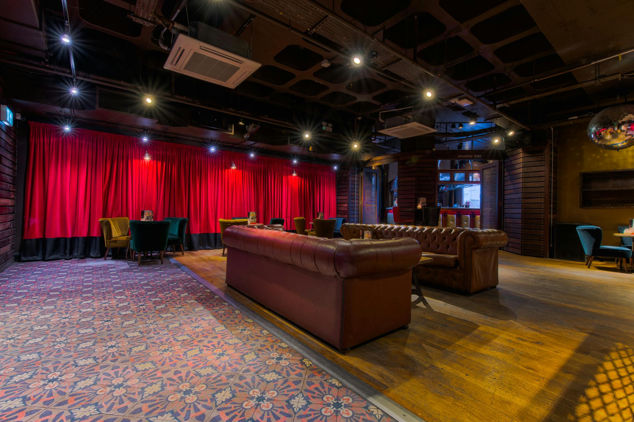 Cozy lounge area in Revolution Ipswich for events, featuring plush seating and vibrant decor.