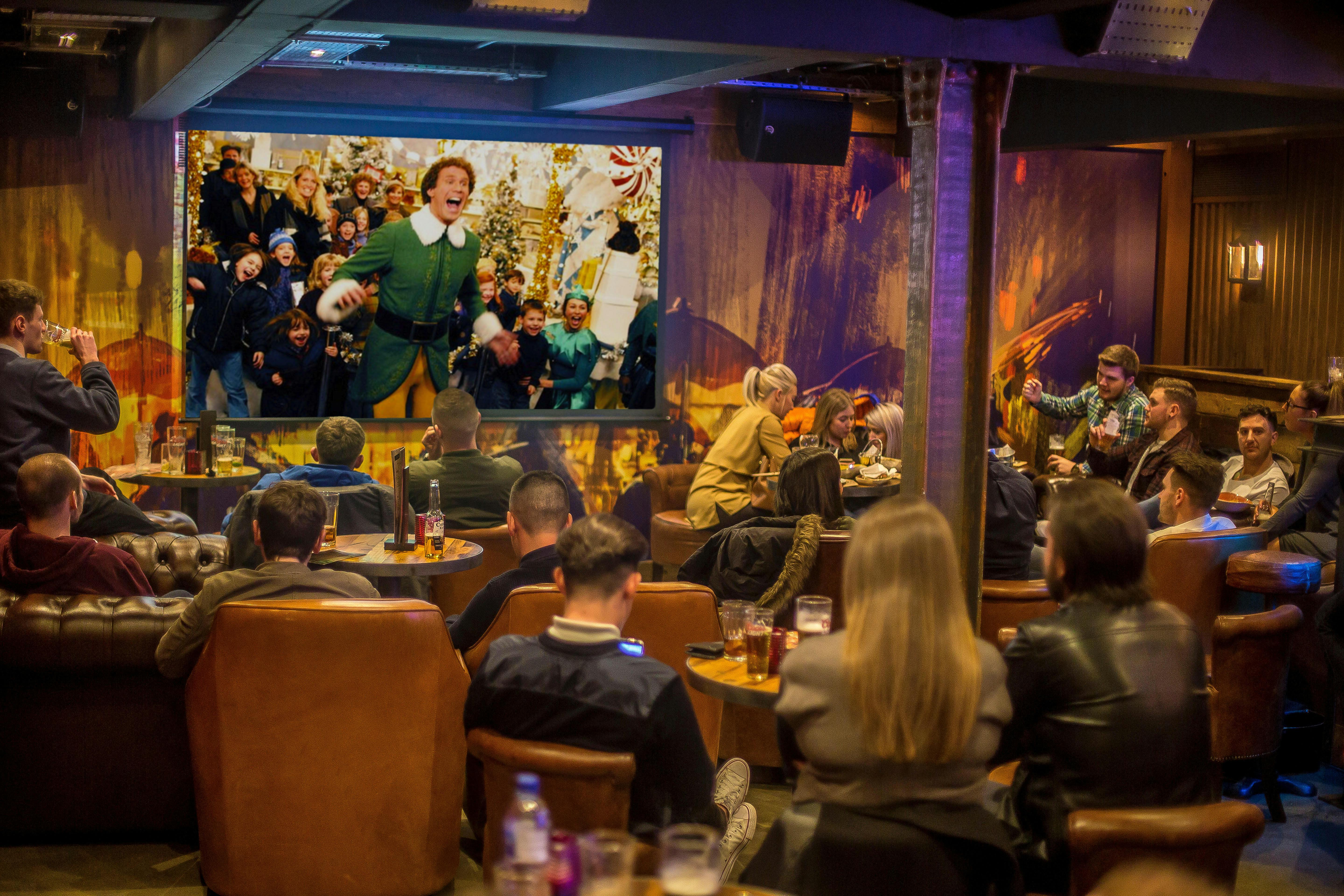 Lively holiday event at The Bar, Dive NQ with festive atmosphere and large screen.