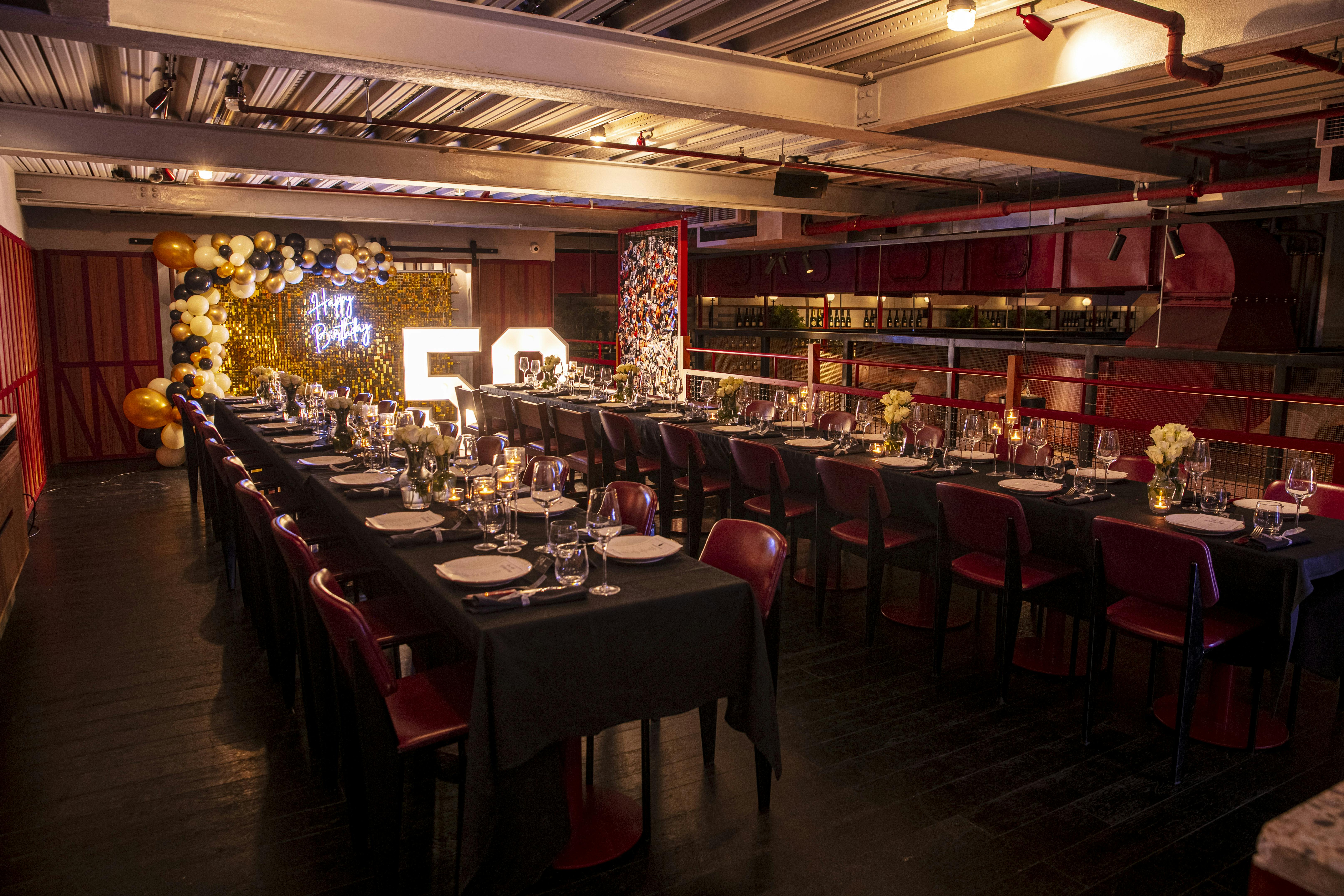 Elegant banquet table with "50" sign for milestone celebration in stylish venue.