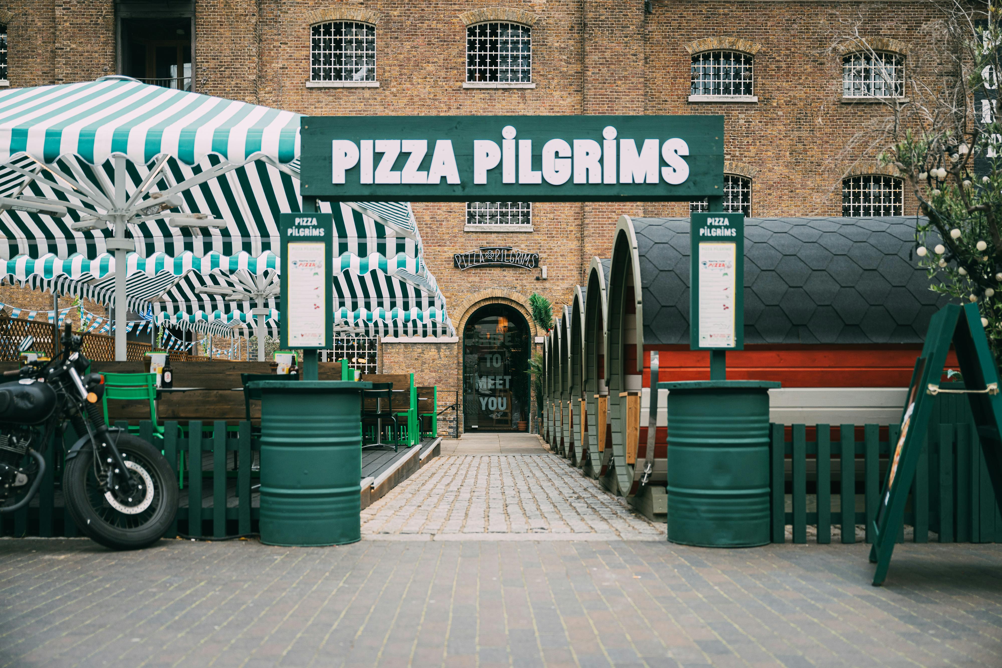 Outdoor terrace at Pizza Pilgrims with colorful canopies, ideal for casual events.