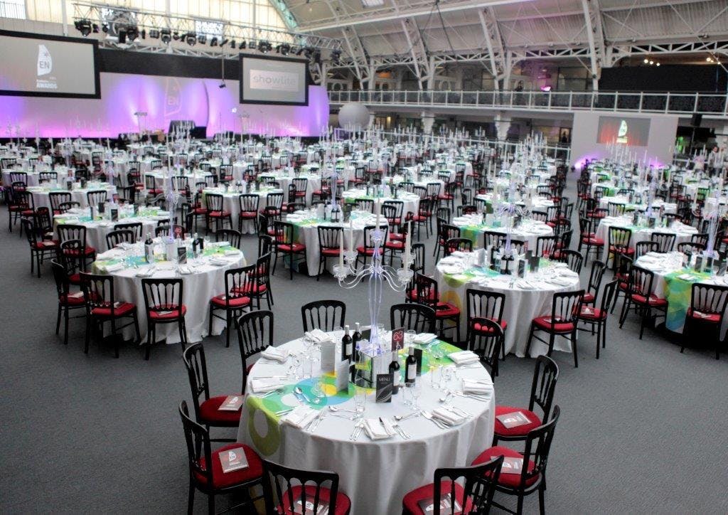 Formal dinner event in Mezzanine, Business Design Centre with elegant tables and red chairs.