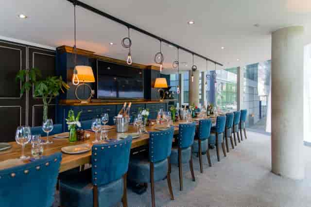 Sophisticated meeting space with wooden table and blue chairs for corporate events.