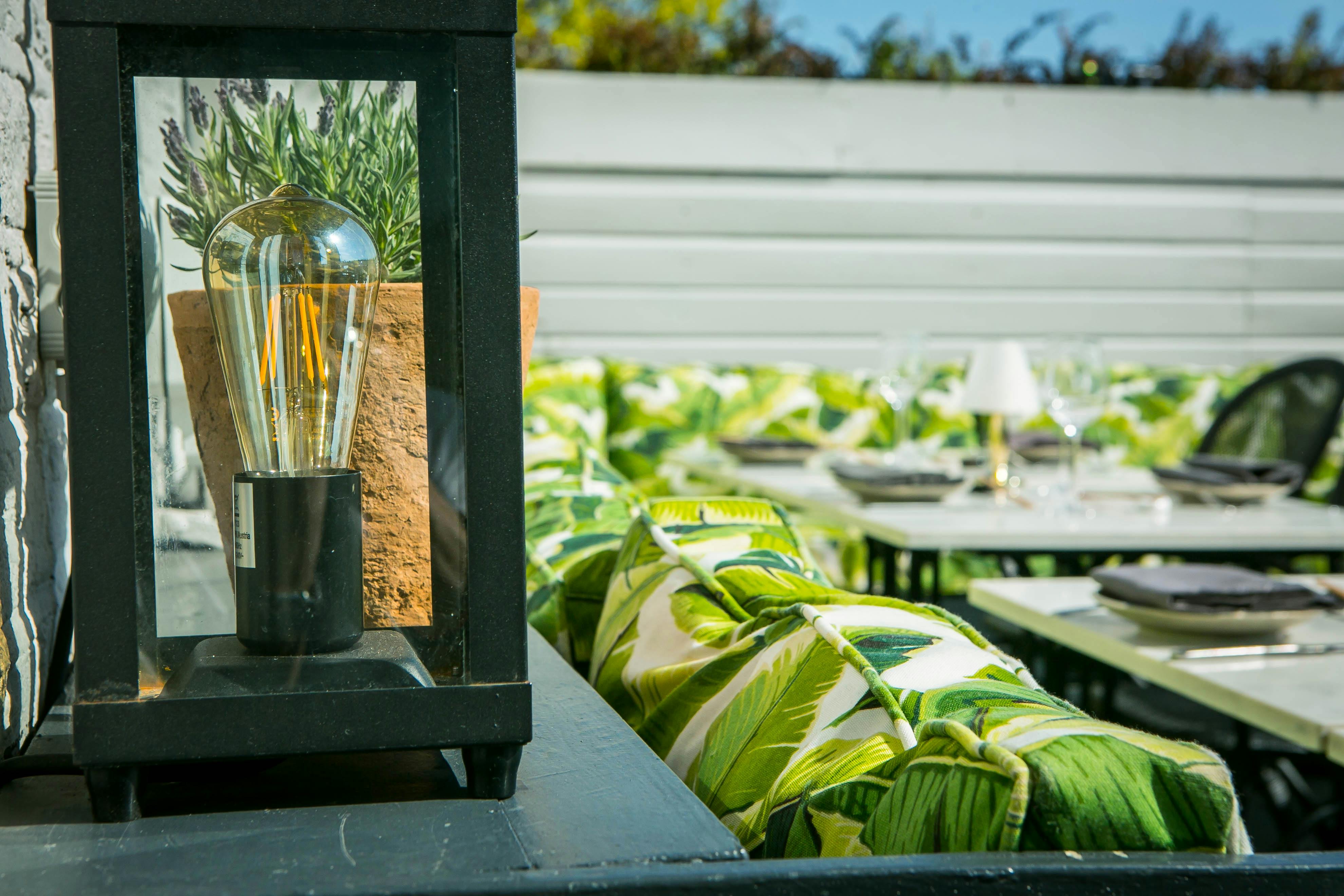 Al Fresco Terrace outdoor event space with tropical seating and warm lantern lighting.