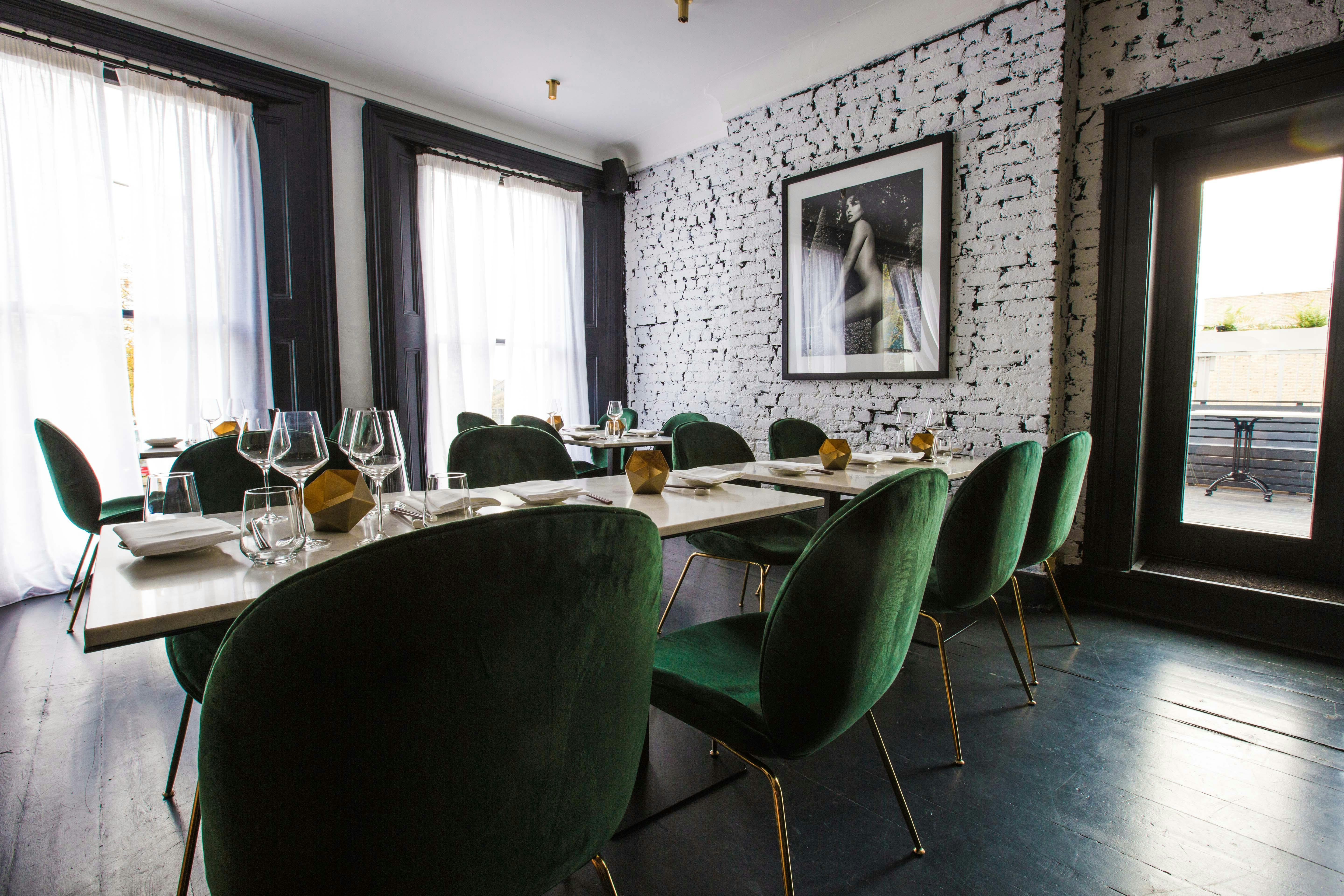 Stylish dining space with green chairs, ideal for private events and networking dinners.