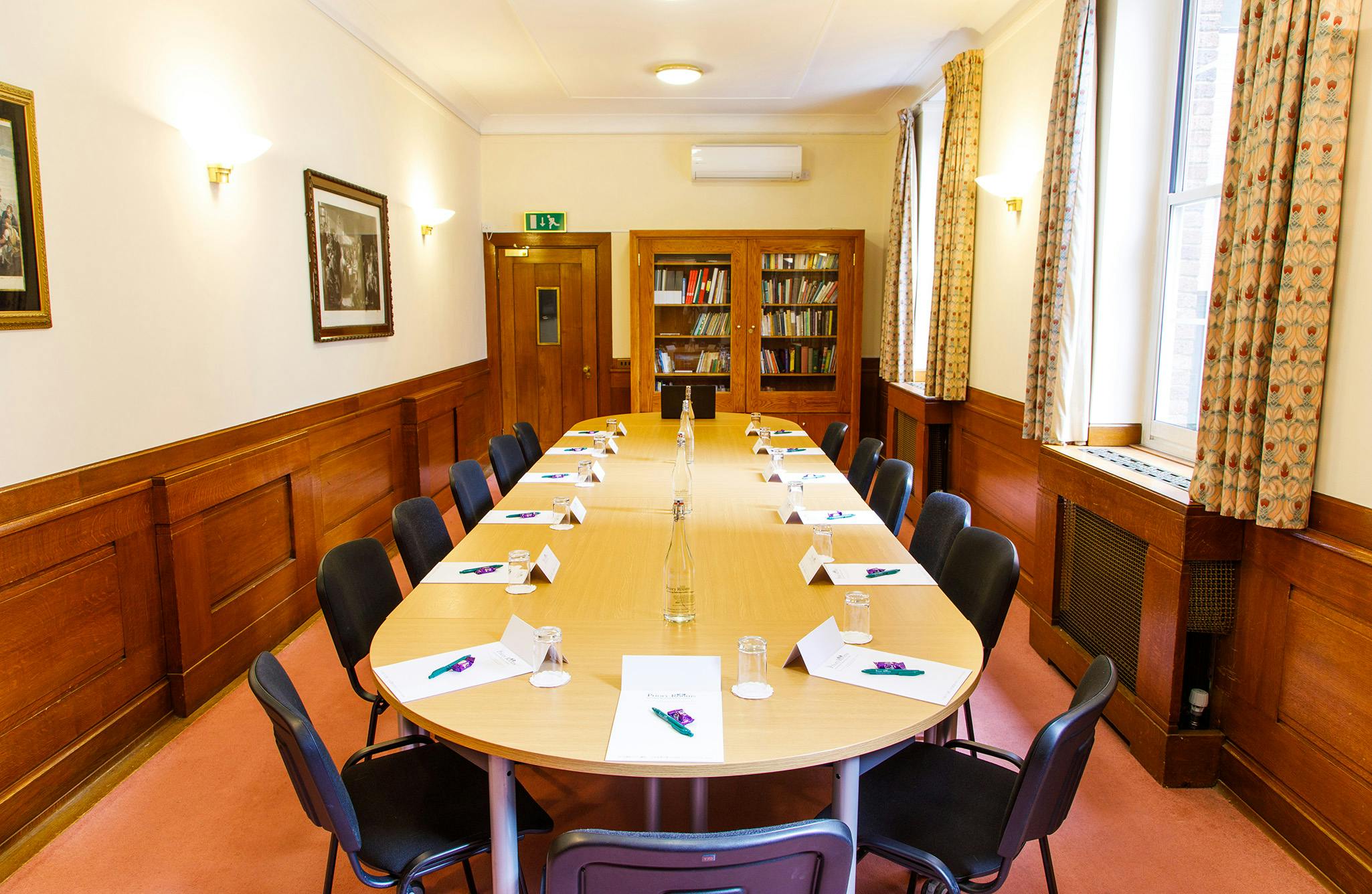 Reading room with oval table, ideal for conferences and meetings.