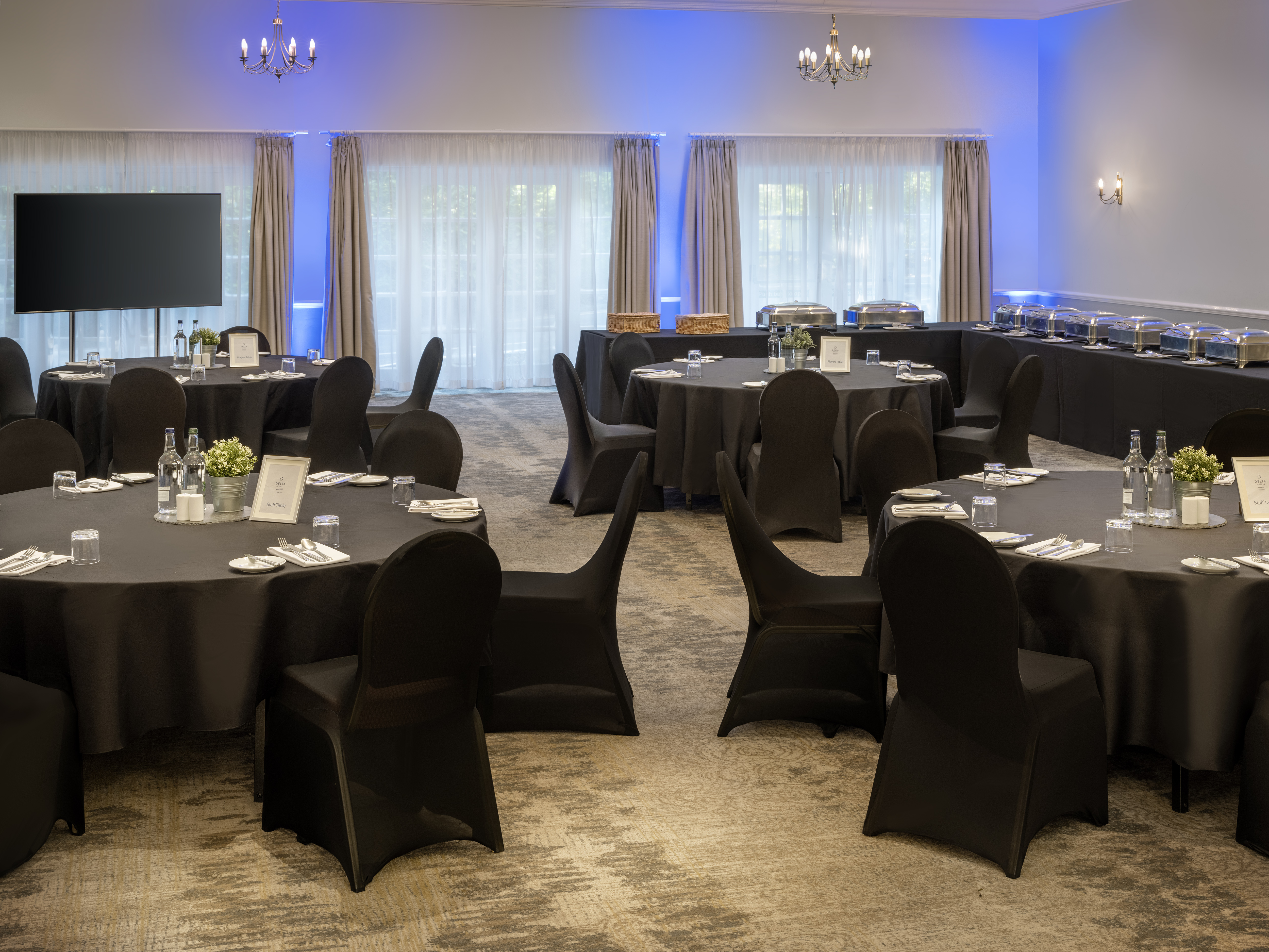 Broughton Suite event space with round tables and ambient blue lighting at Delta Hotels.