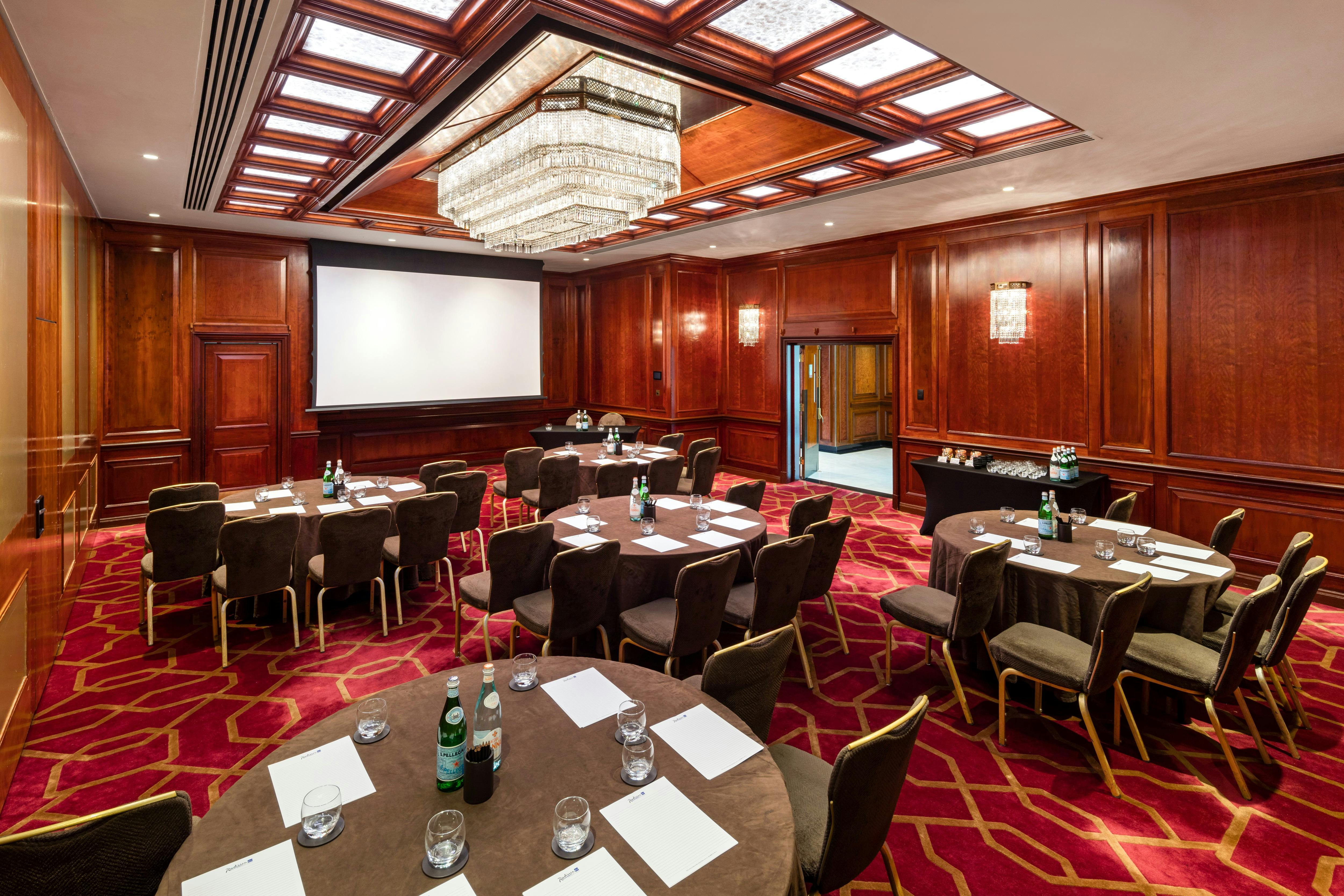 Sophisticated meeting room at Radisson Blu Heathrow with elegant wood paneling for corporate events.