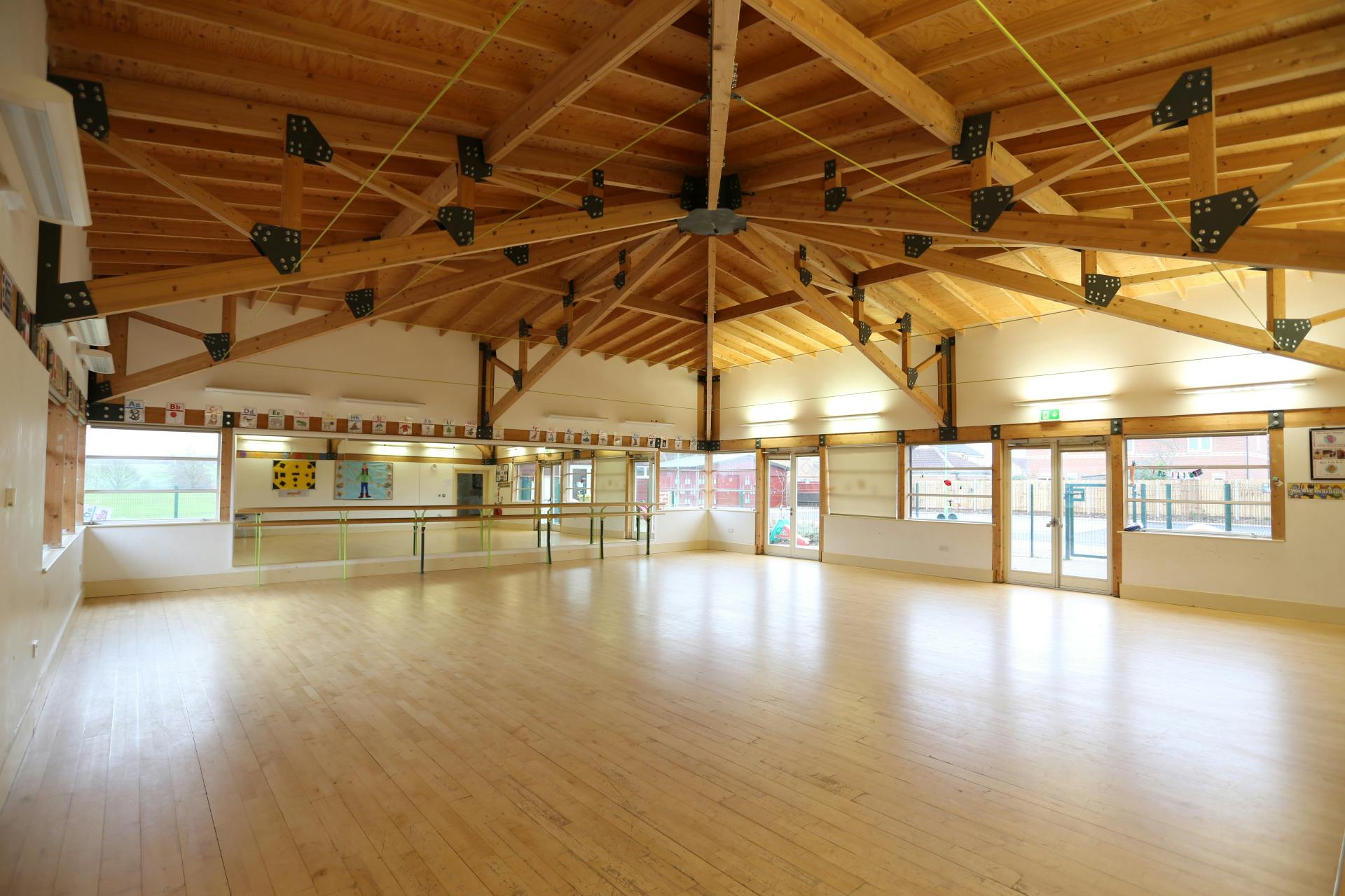 Kingspan Hall in Gamlingay Eco Hub: spacious event space with high wooden ceiling, ideal for workshops.