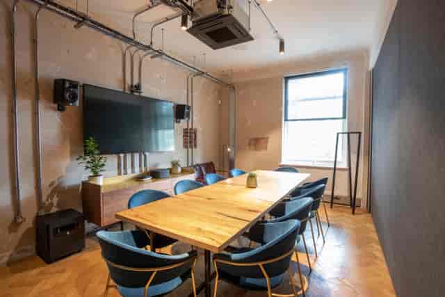 Industrial-chic meeting room with warm wood for strategy sessions and collaborative workshops.