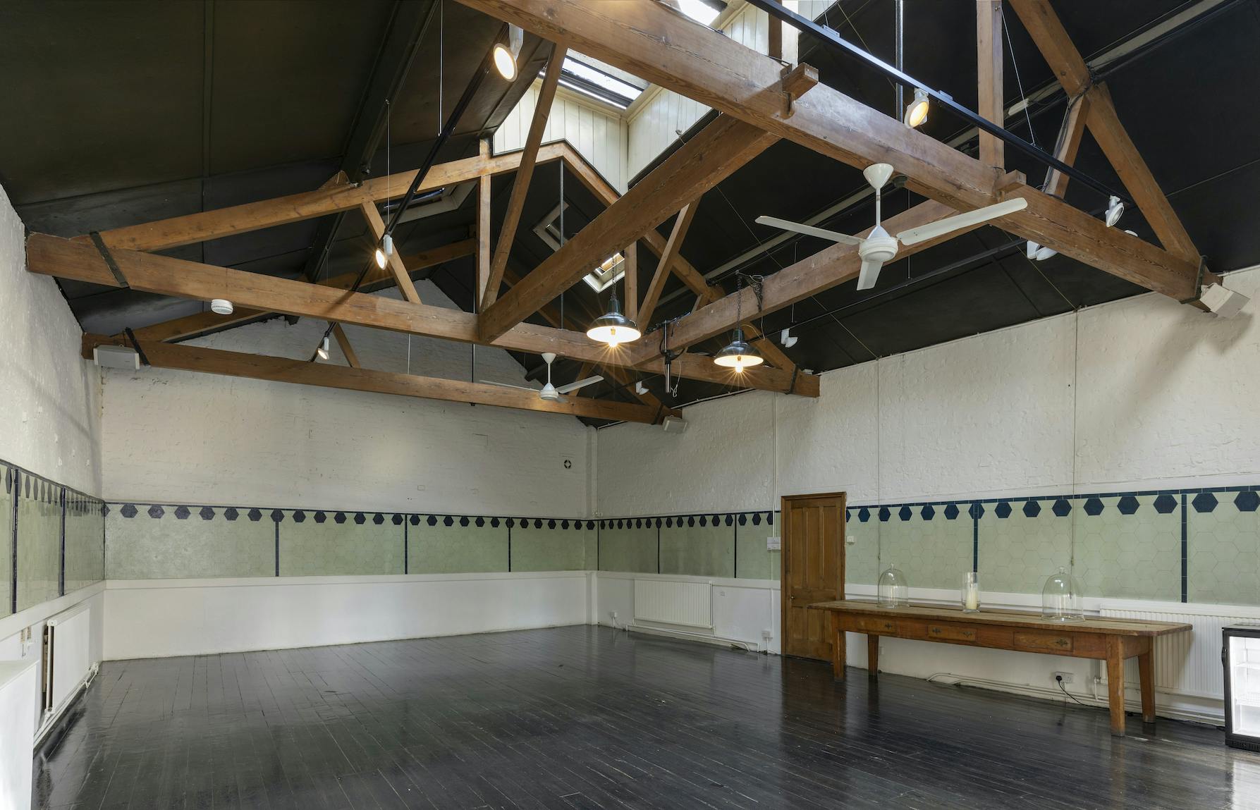 Spacious event space with high ceilings in The Stables, Park Village for meetings and workshops.