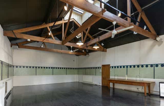 Spacious event space with high ceilings in The Stables, Park Village for meetings and workshops.