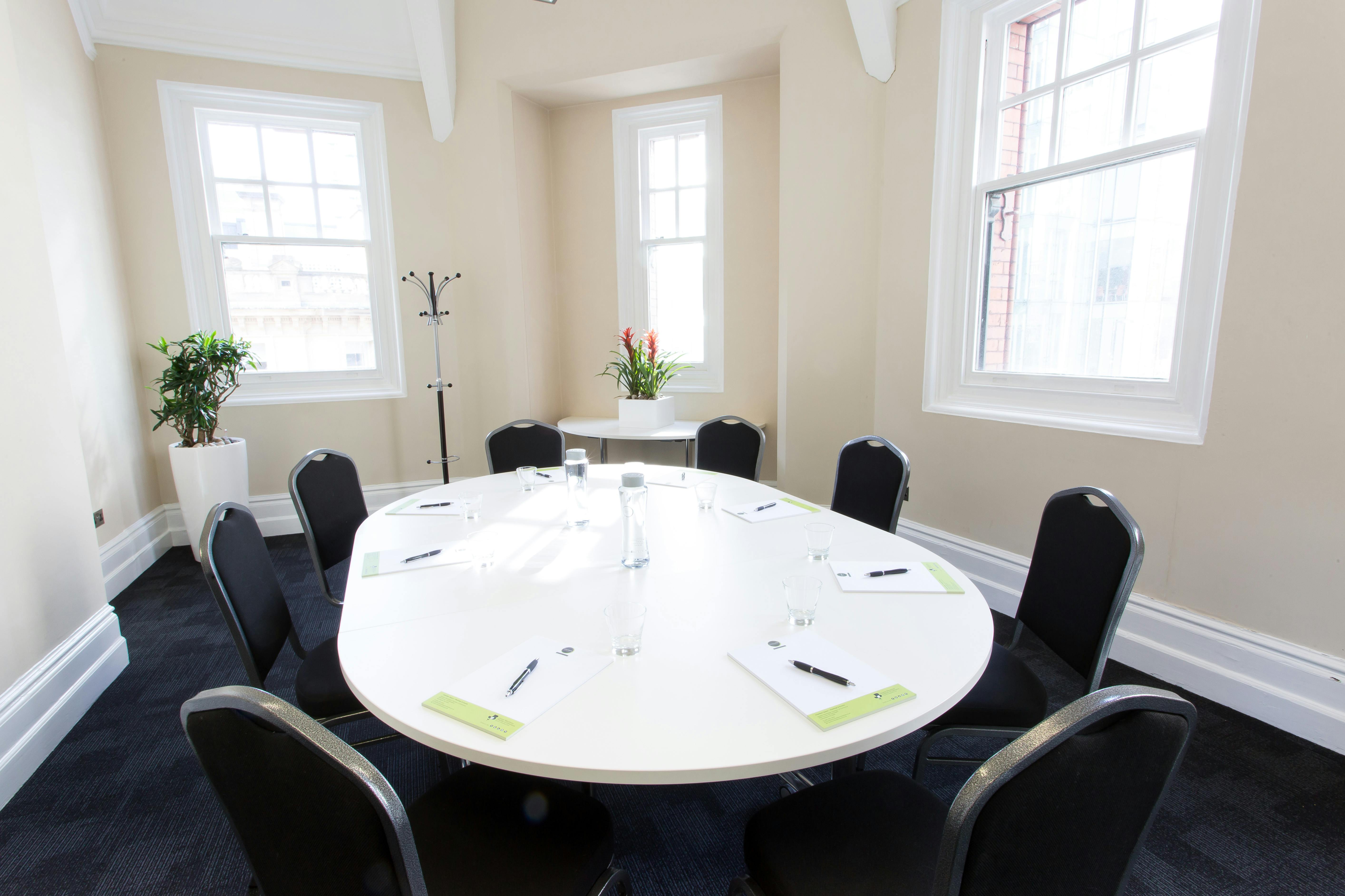 Pankhurst Room: bright meeting space with round table for productive discussions and events.