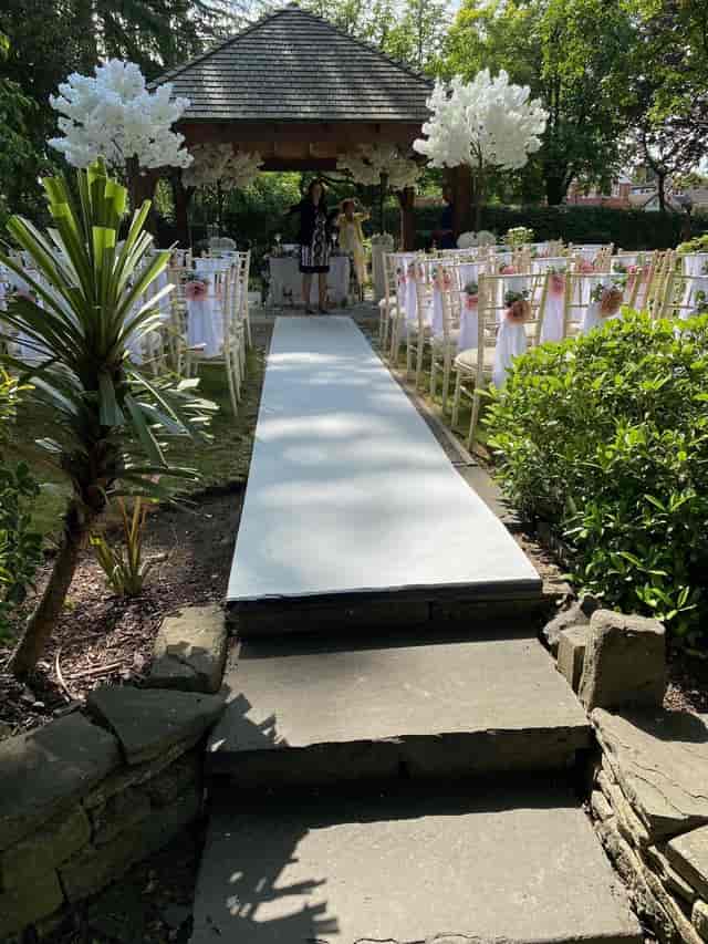 Cheshire Suite outdoor wedding venue with floral chairs and lush greenery.