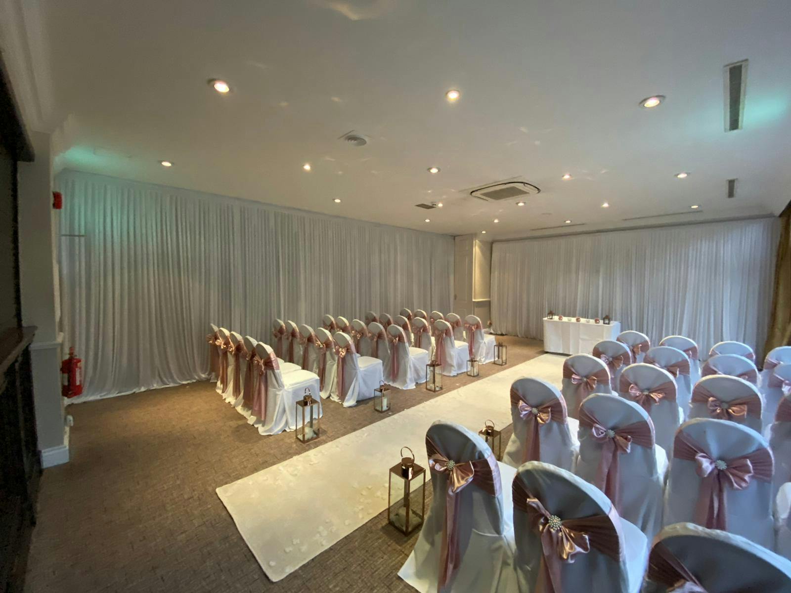 Cheshire Suite at Best Western Plus, elegant wedding venue with white drapery and pink sashes.