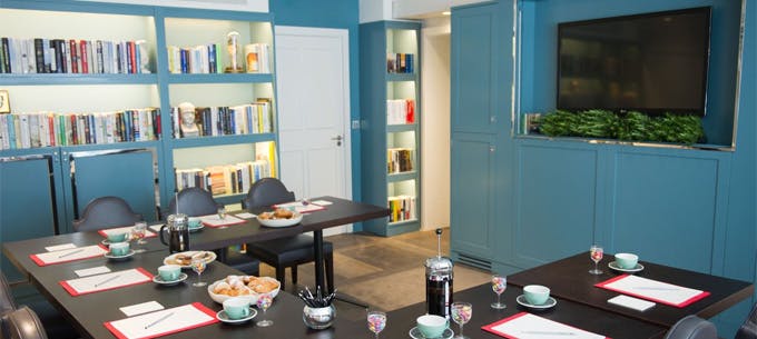 Modern meeting room at The Ampersand Hotel with blue walls, ideal for workshops.