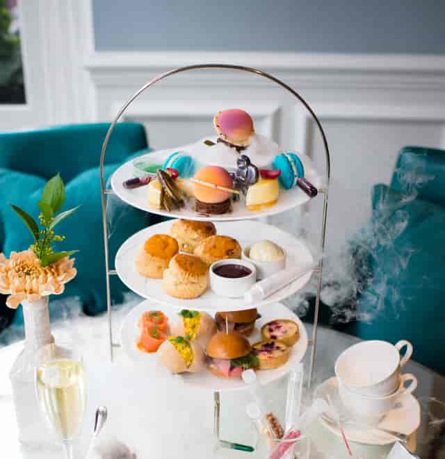 Elegant tiered dessert display with macarons for upscale afternoon tea at The Ampersand Hotel.