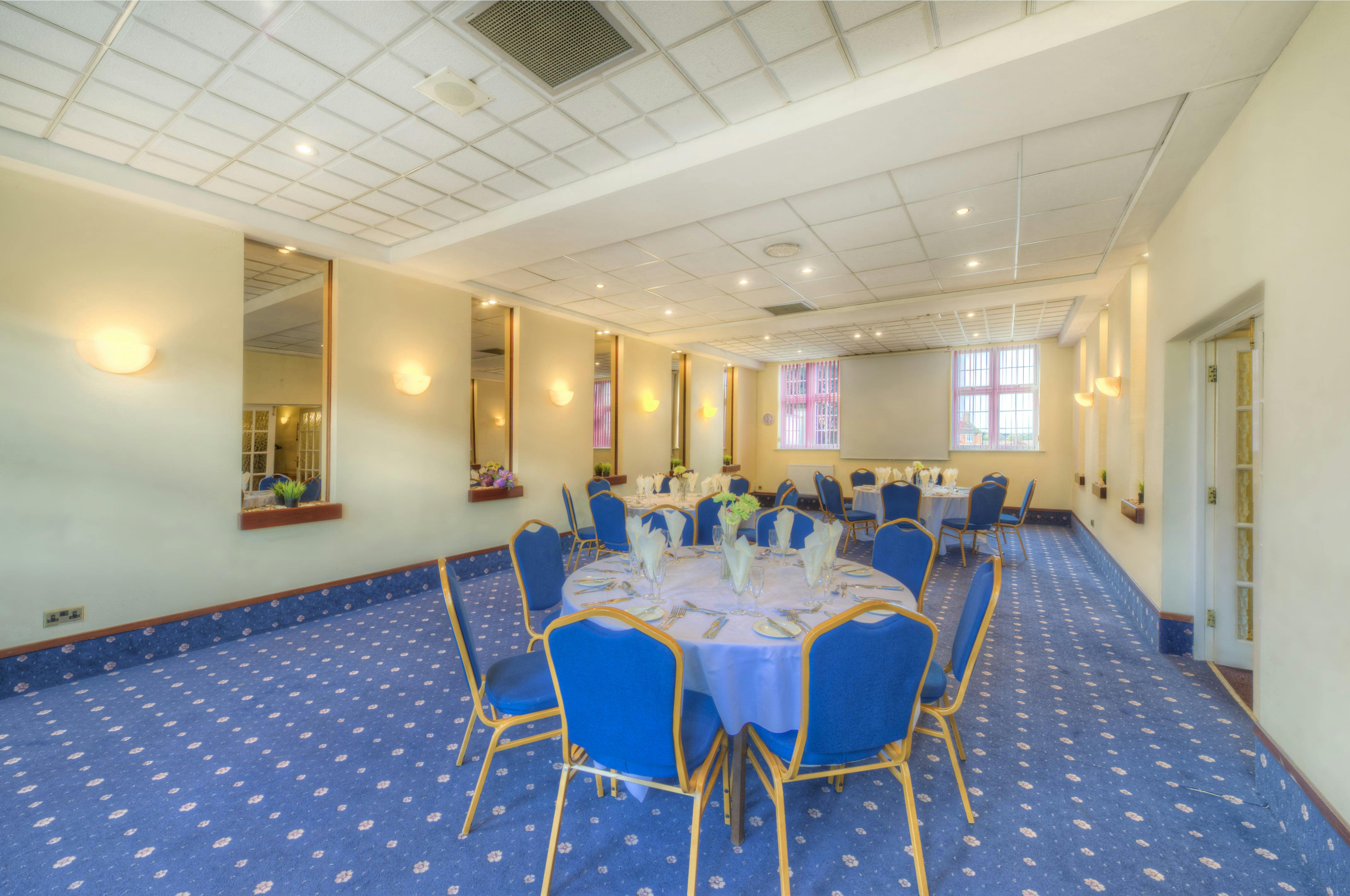 Meriden Suite at Quality Hotel Coventry, bright event space with round tables and blue chairs.