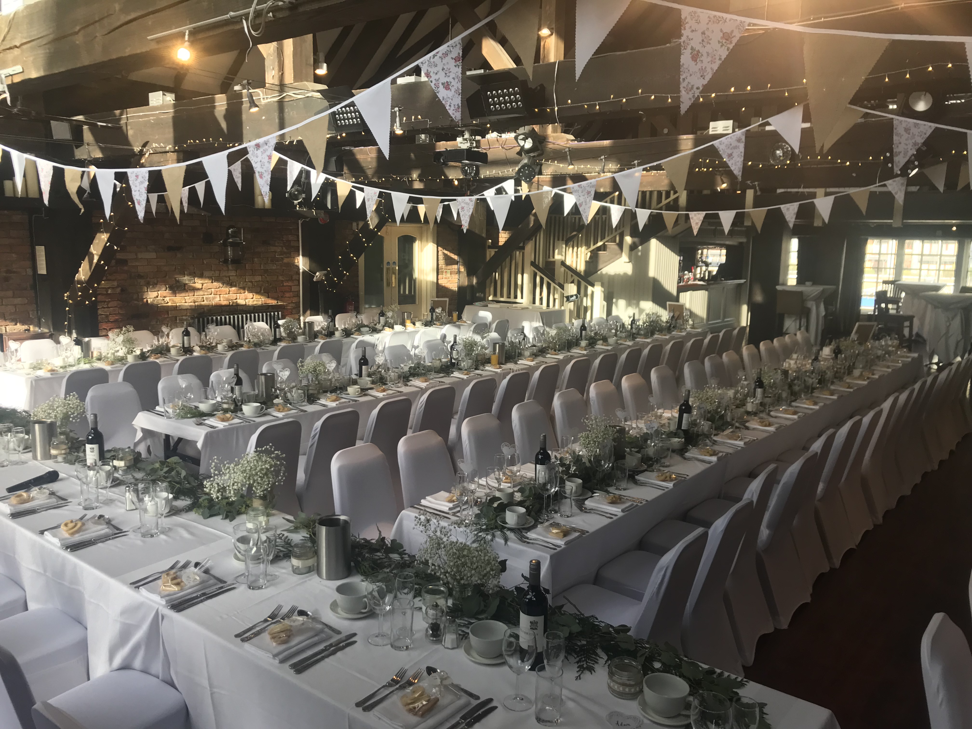 Elegant wedding event space at Dickens Inn with long tables and charming decor. - Banner