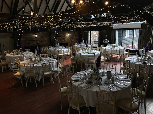 Elegant event space at Dickens Inn, perfect for weddings with round tables and fairy lights.