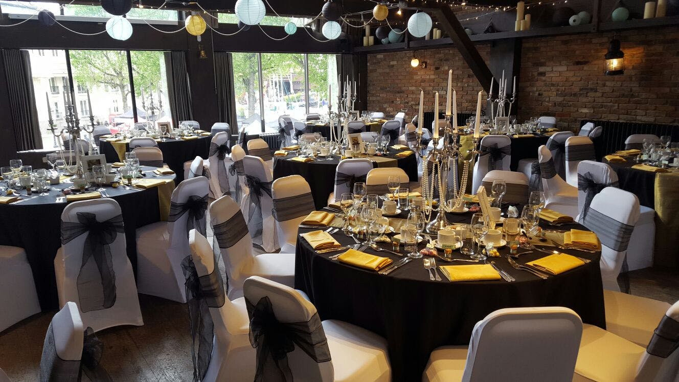 Elegant event space at Dickens Inn with black and gold decor for formal gatherings.